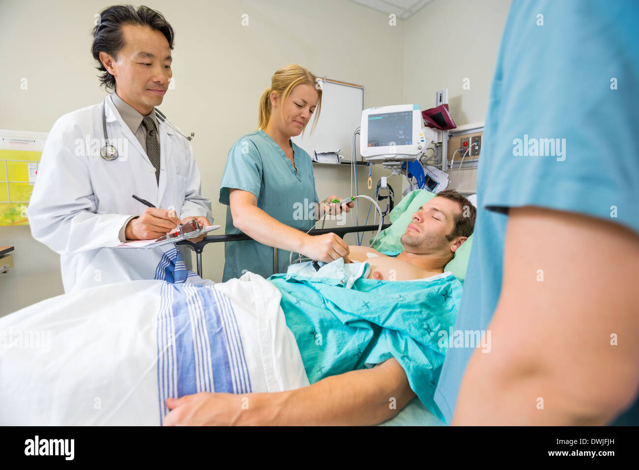Patient Being Examined By Doctors In Hospital Stock Photo
