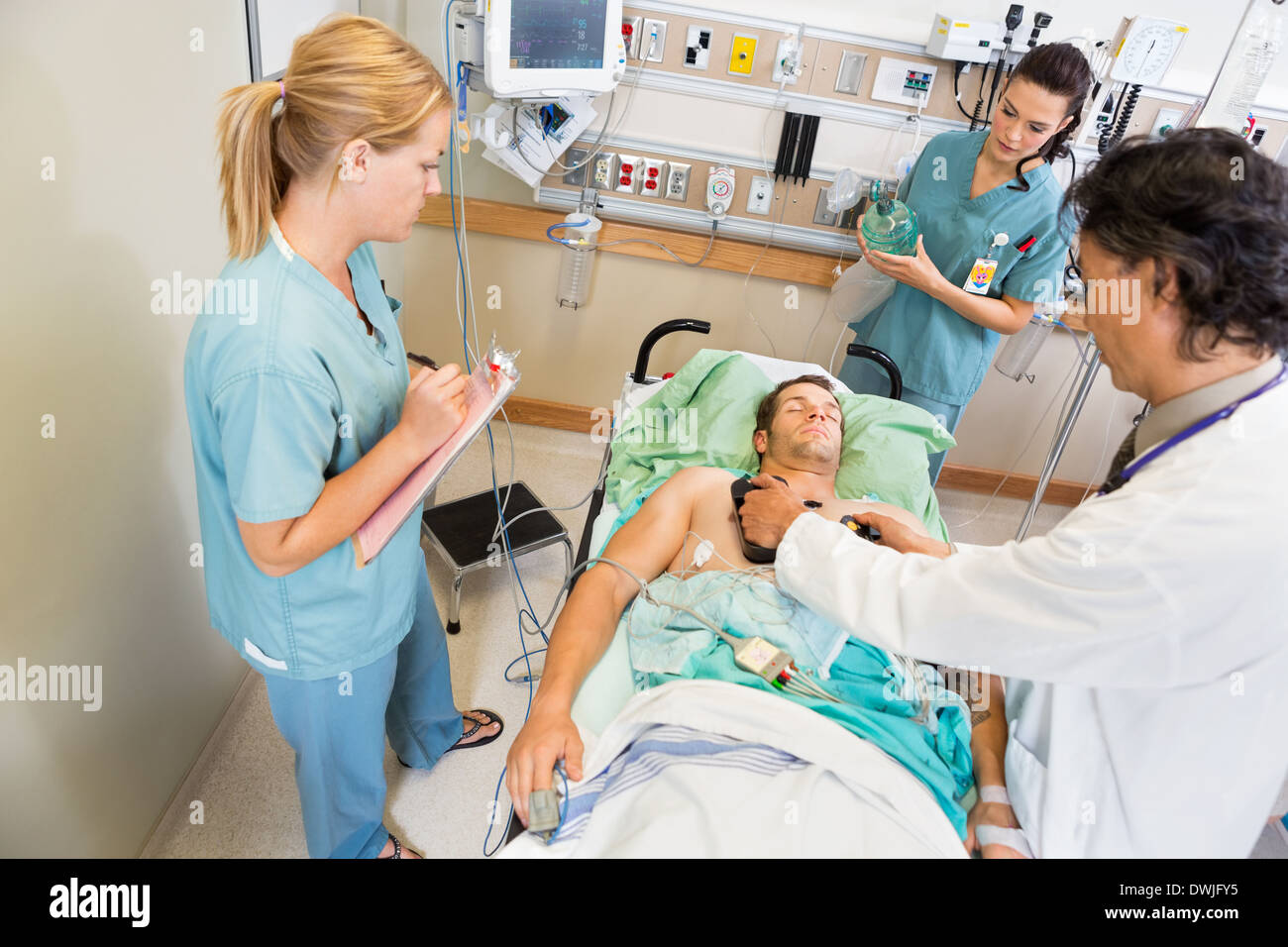 Doctor Defibrillating Critical Patient In Hospital Stock Photo