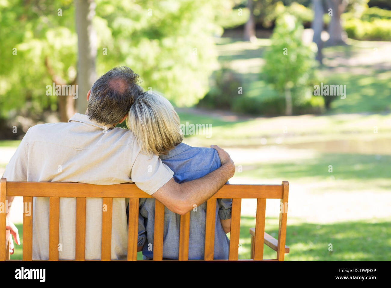 Couple relaxing on park bench Stock Photo - Alamy