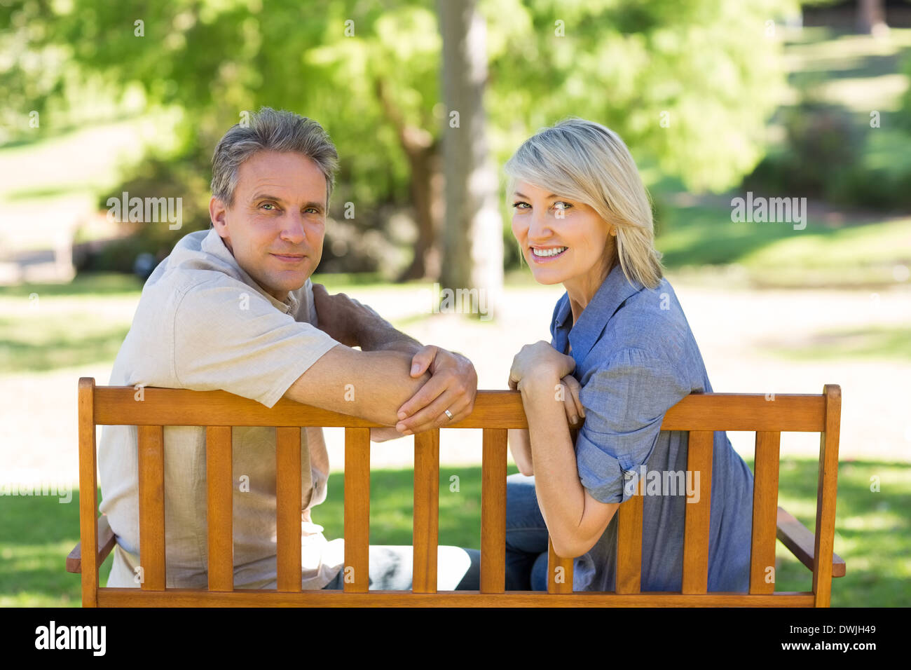 Happy couple relaxing on park bench Stock Photo - Alamy