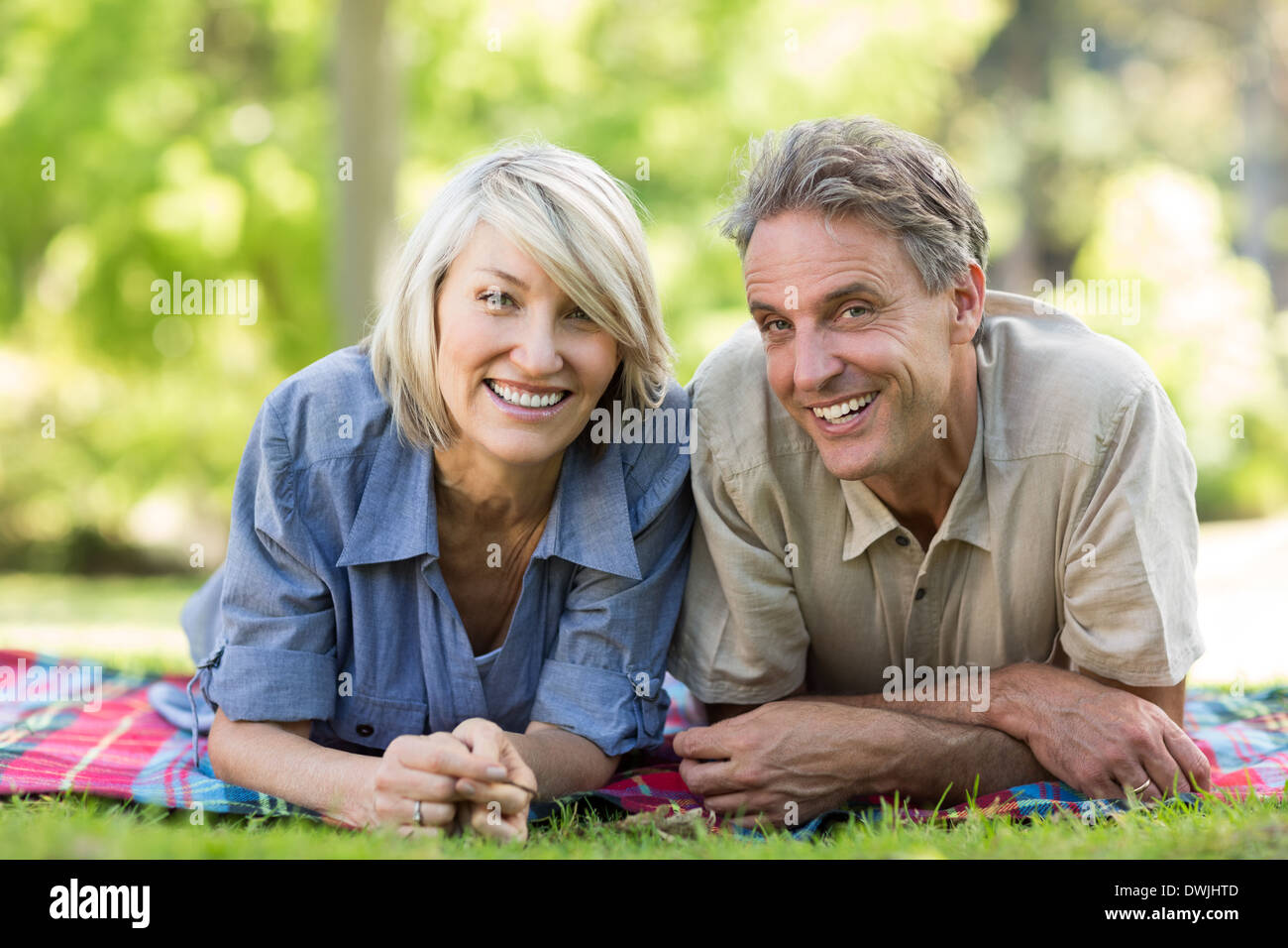 Couple lying on blanket in park Stock Photo