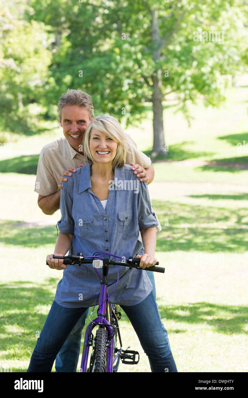 Couple riding bicycle in park Stock Photo
