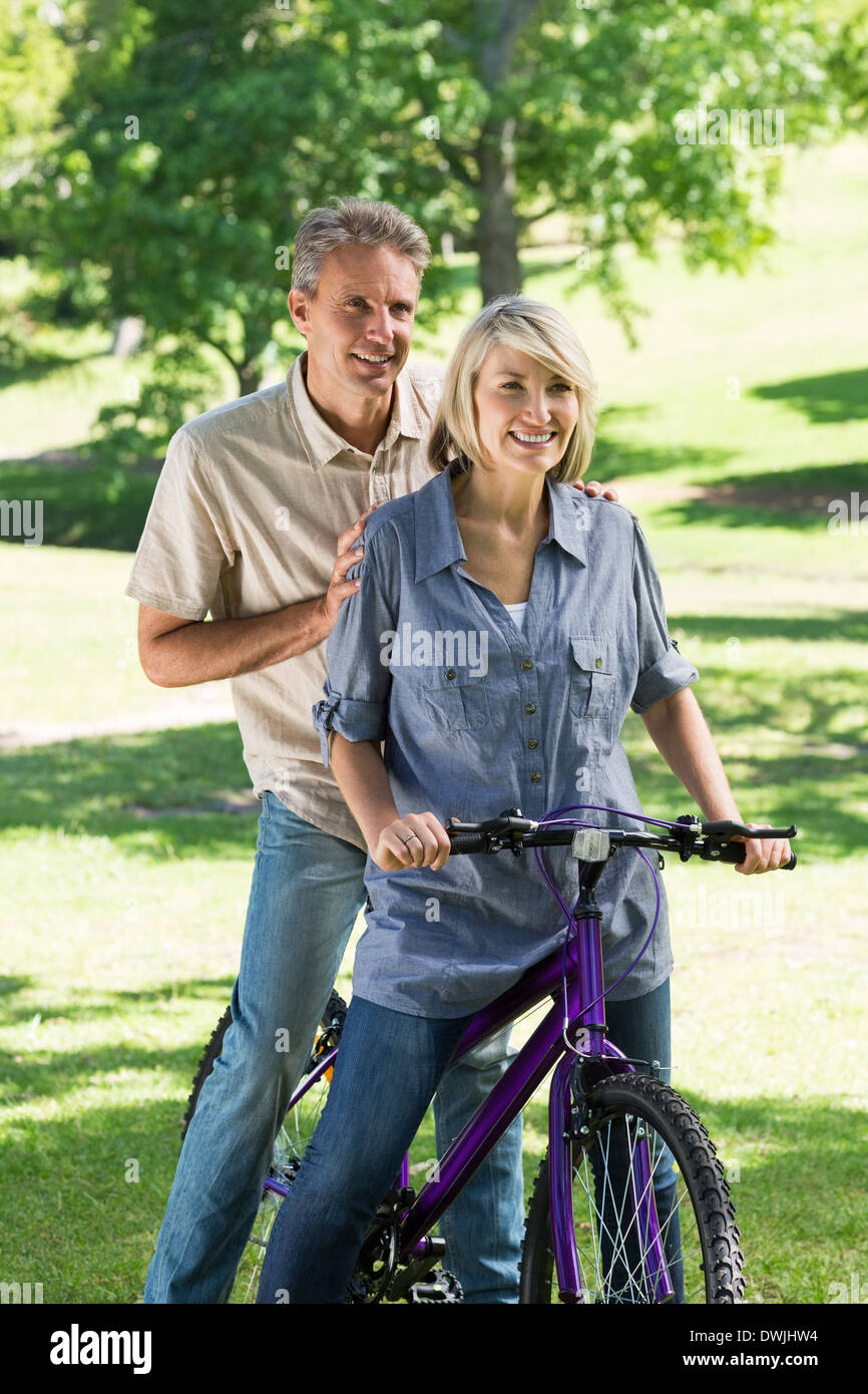 Couple riding bicycle in park Stock Photo