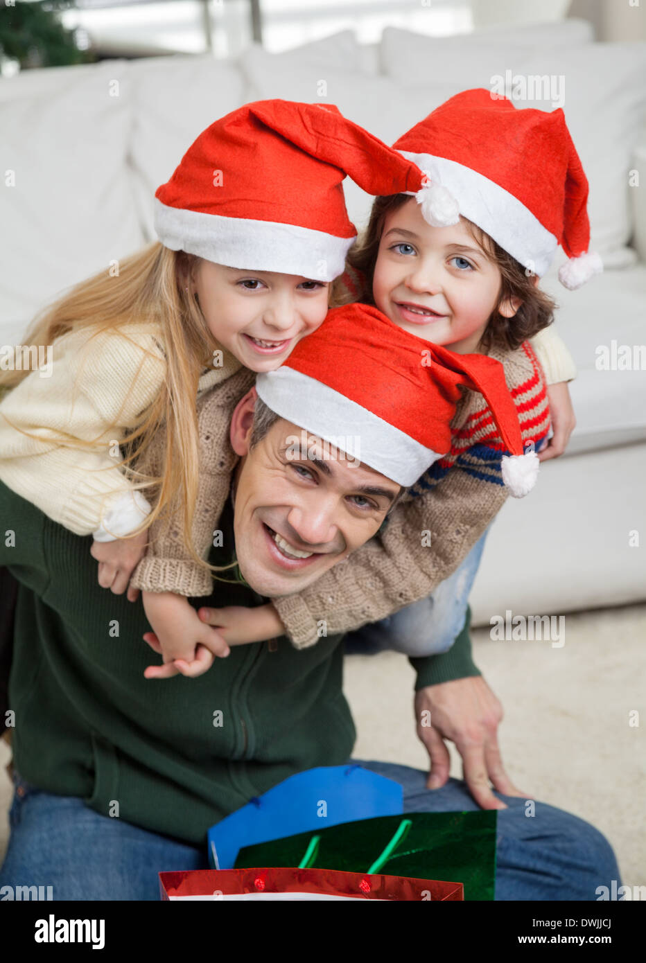 Father Piggybacking Children During Christmas Stock Photo