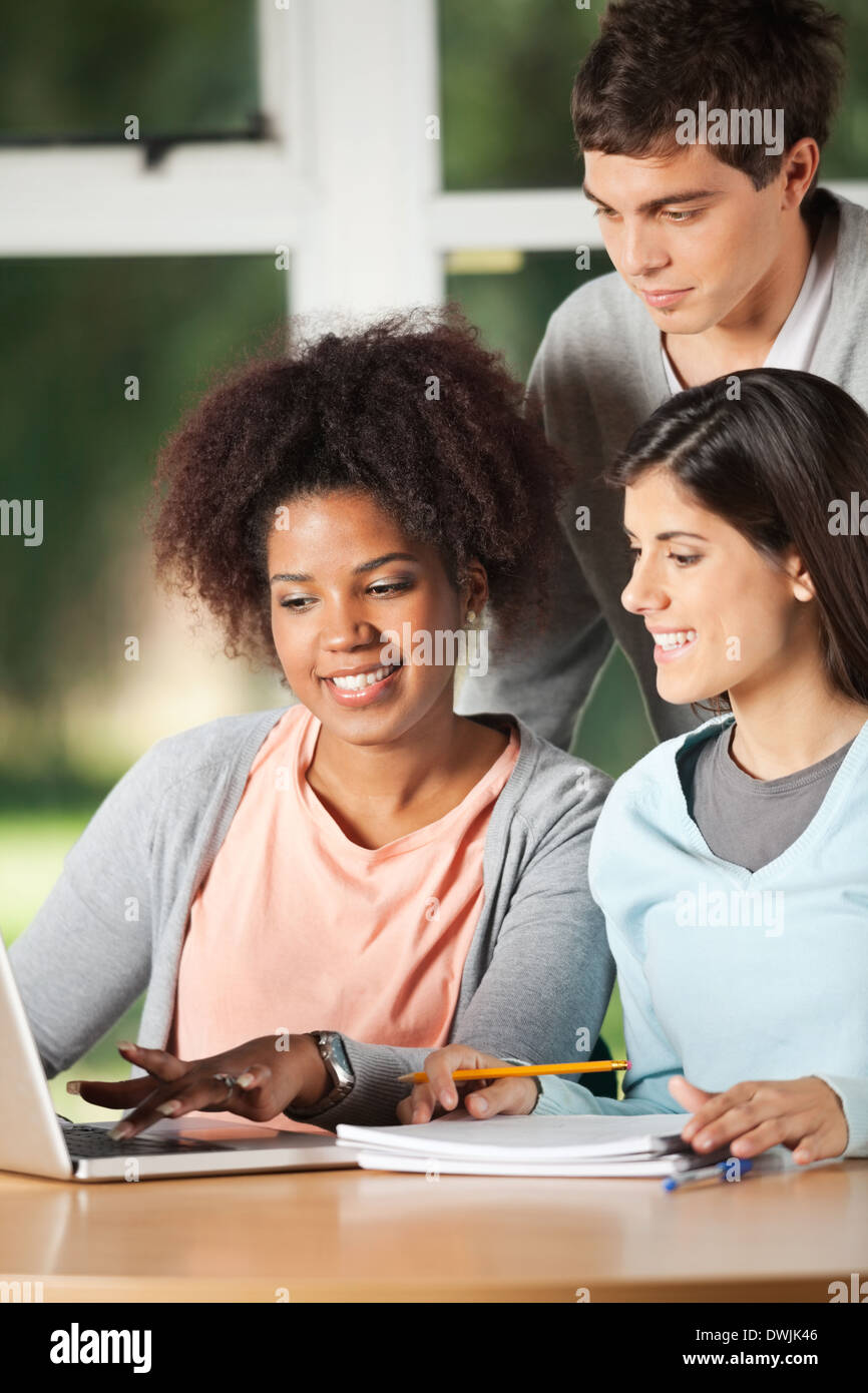 Friends Using Laptop At Desk In Classroom Stock Photo Alamy