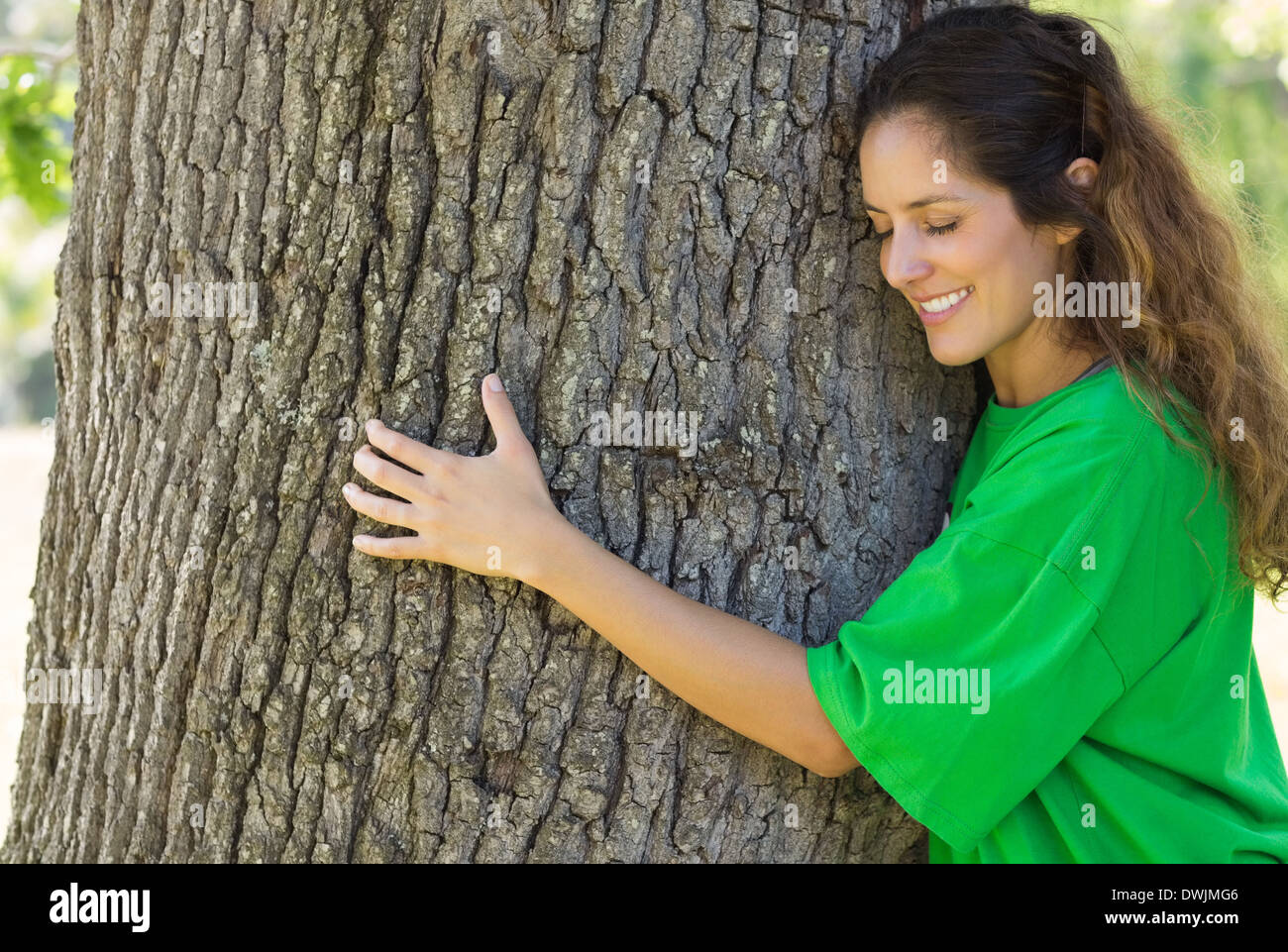 Environmentalist hugging tree trunk Stock Photo - Alamy