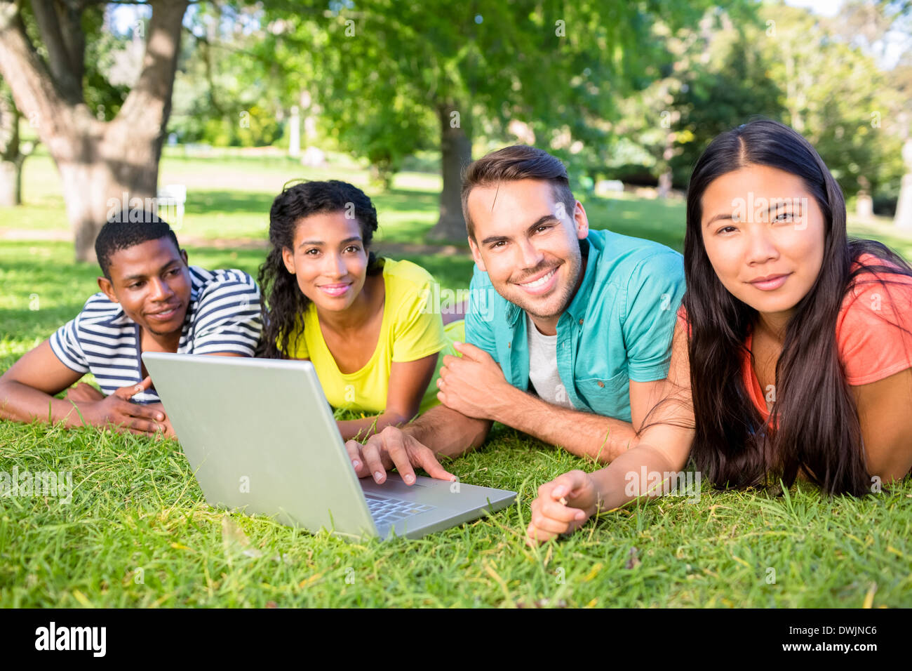 Smiling students with laptop on campus Stock Photo