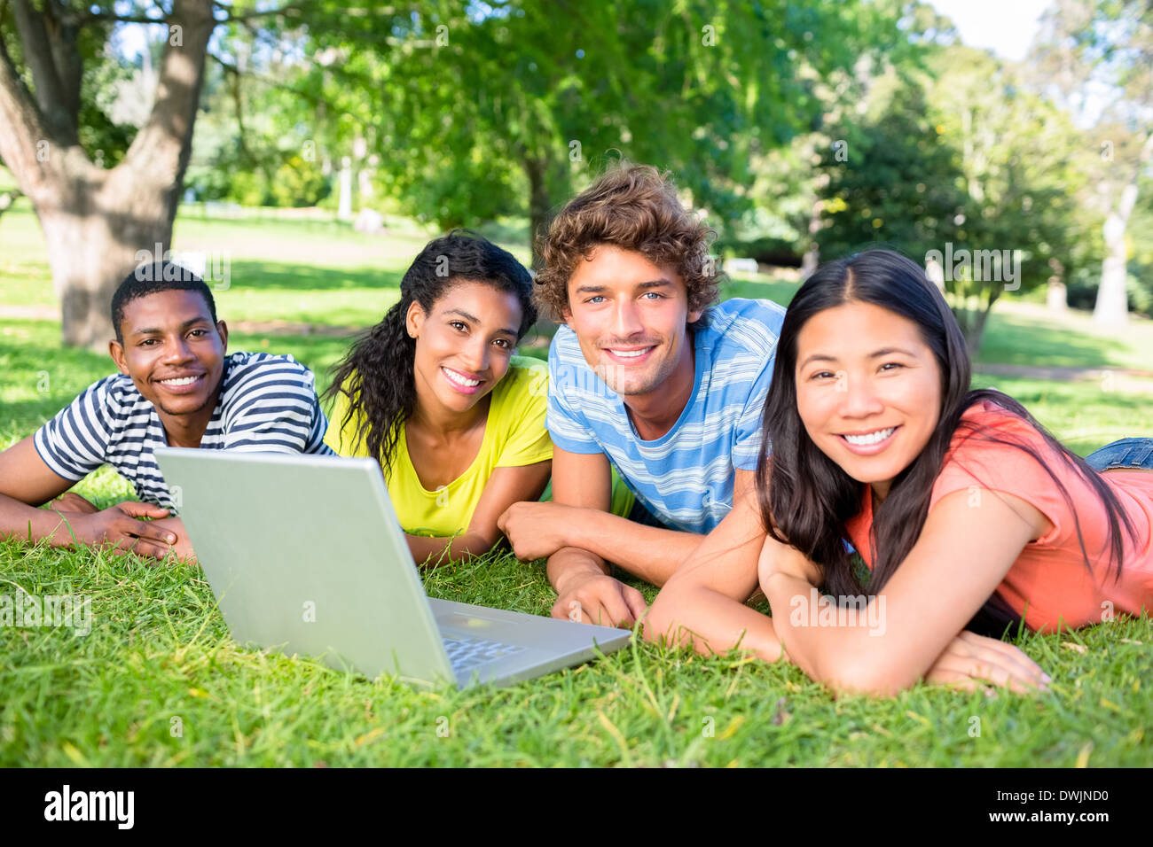 Students with laptop lying on campus Stock Photo