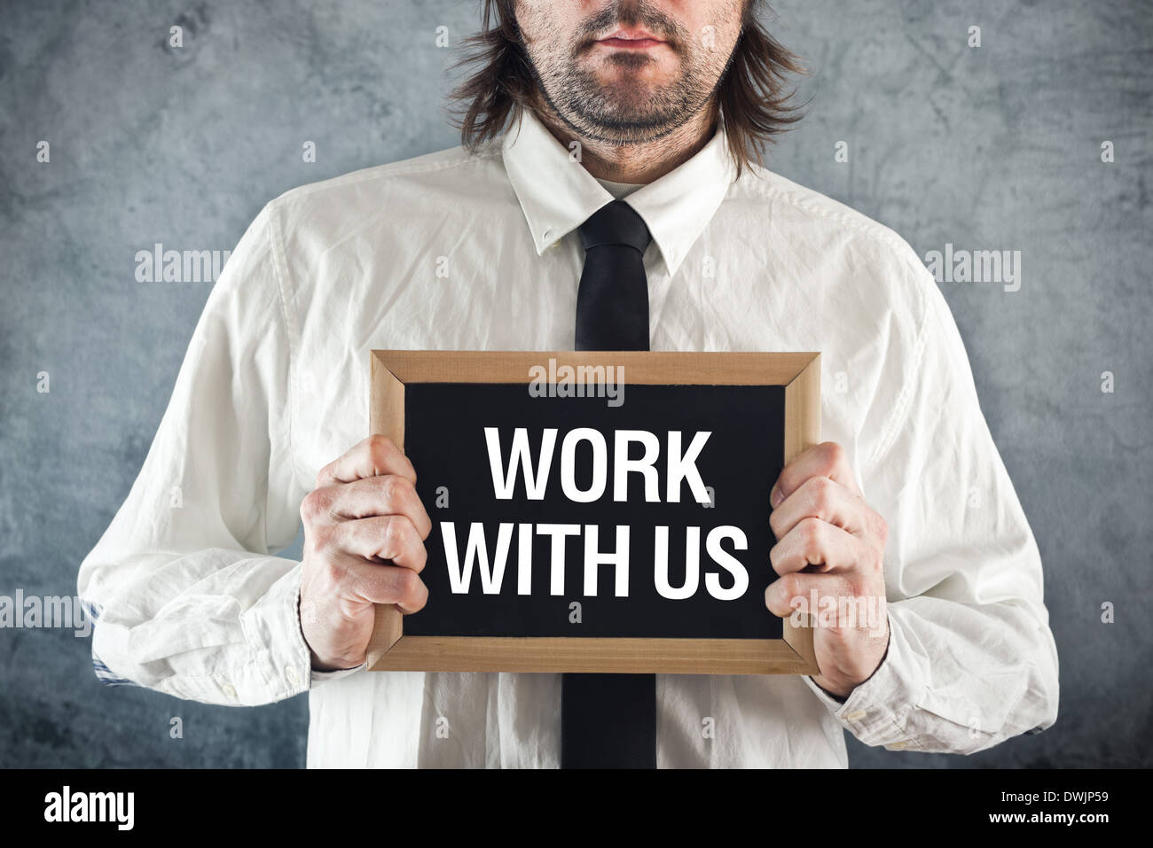 Businessman holding blackboard with WORK WITH US title. Business concept. Stock Photo