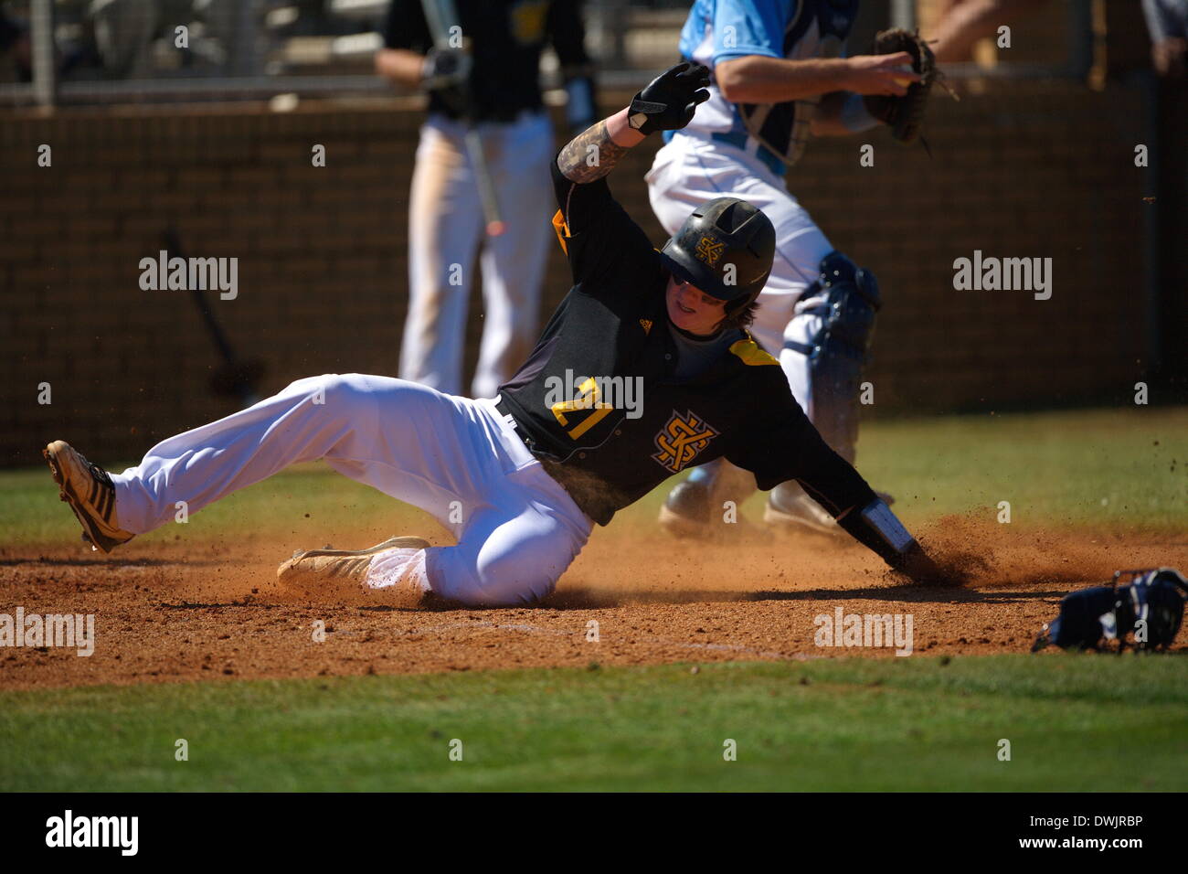 Kennesaw, Georgia, USA.  March 8, 2014 -- Catcher Brennan Morgan (21) slides in safely for KSU during the first game of Saturday's doubleheader between Columbia University and Kennesaw State University. The teams split the doubleheader. Credit:  Wayne Hughes | Alamy Live News Stock Photo