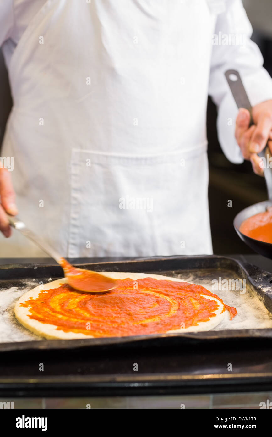 Mid section of a chef preparing pizza in kitchen Stock Photo