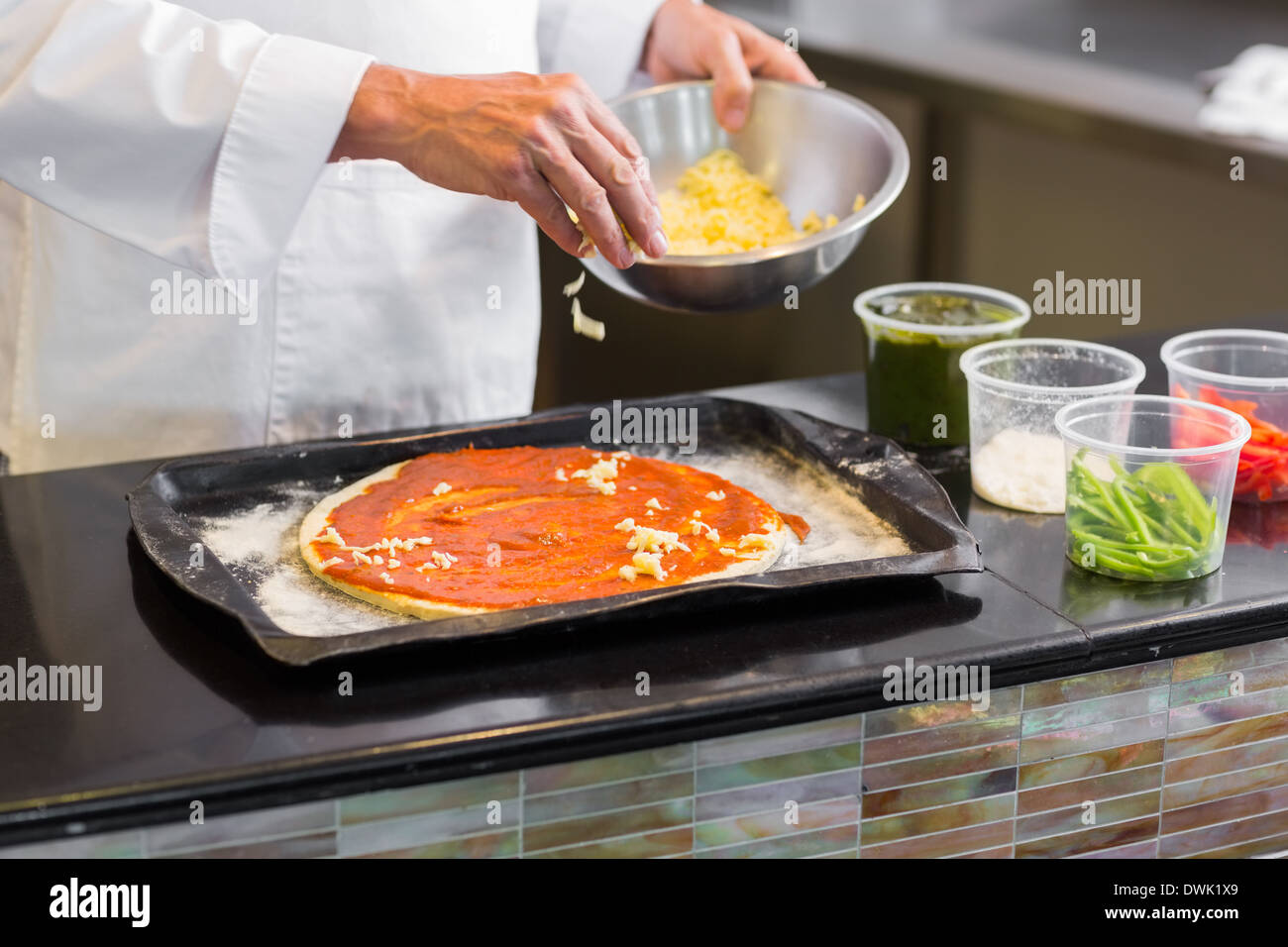 Mid section of a chef garnishing food in kitchen Stock Photo