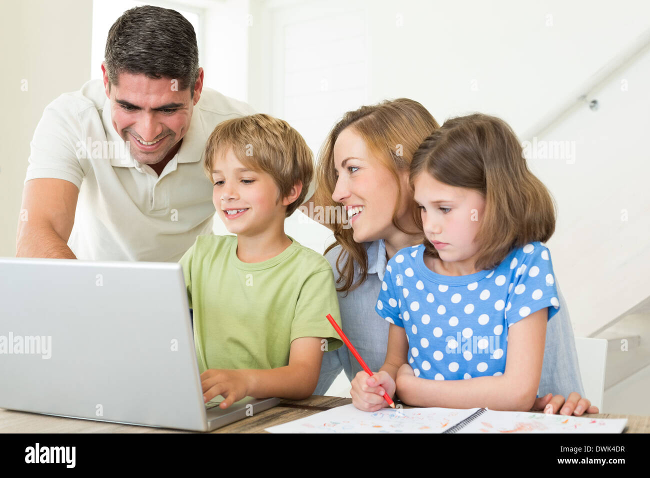 Family using laptop at table Stock Photo
