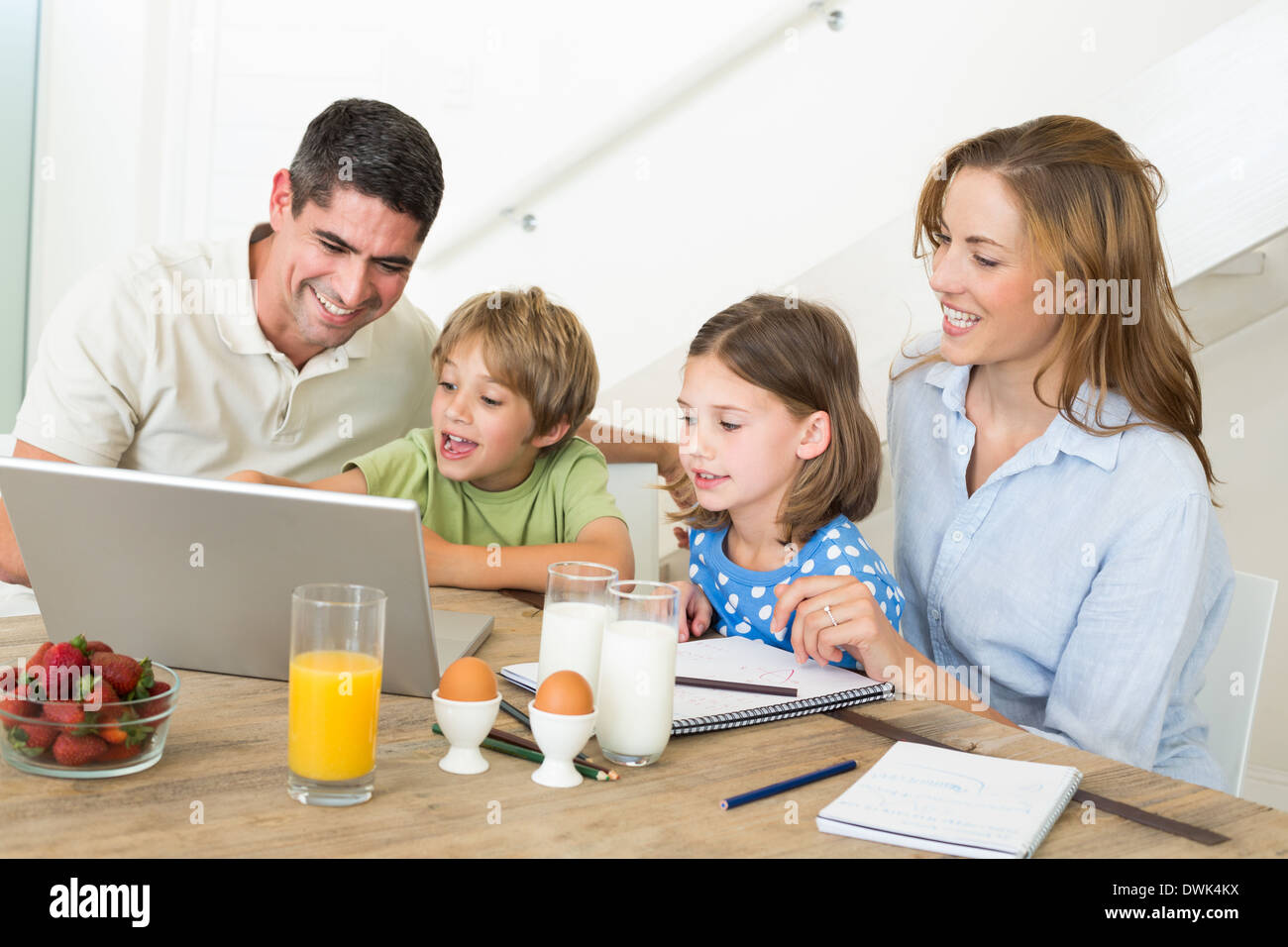 Family using laptop while having breakfast Stock Photo