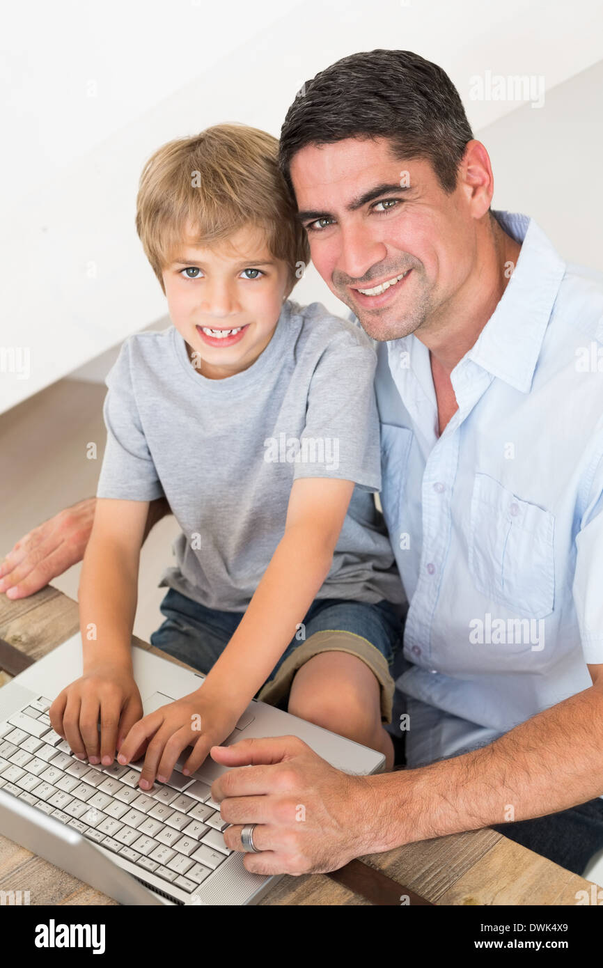 Happy father and son using laptop Stock Photo