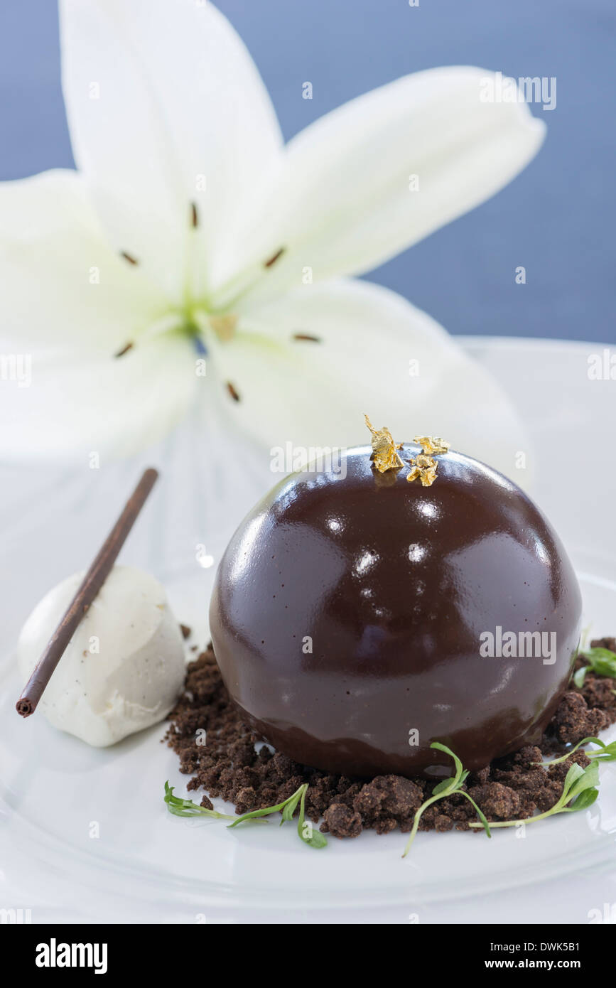 Chocolate bombe dessert served with vanilla ice cream Stock Photo