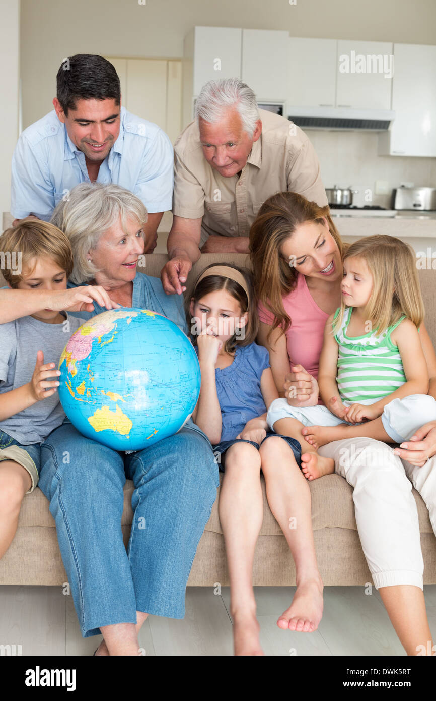 Family exploring globe in living room Stock Photo Alamy