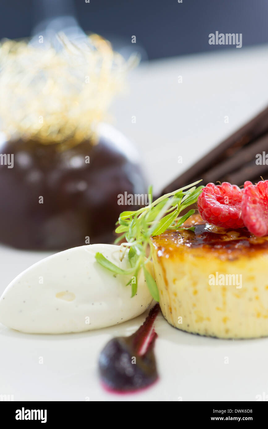 Trio of desserts, including Crème brûlée, chocolate flan and chocolate bombe. Stock Photo