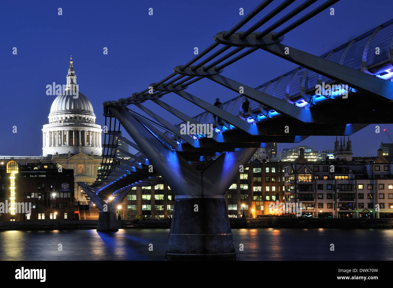 The Millennium Bridge, London UK, at night, with St Paul's Cathedral dome behind Stock Photo