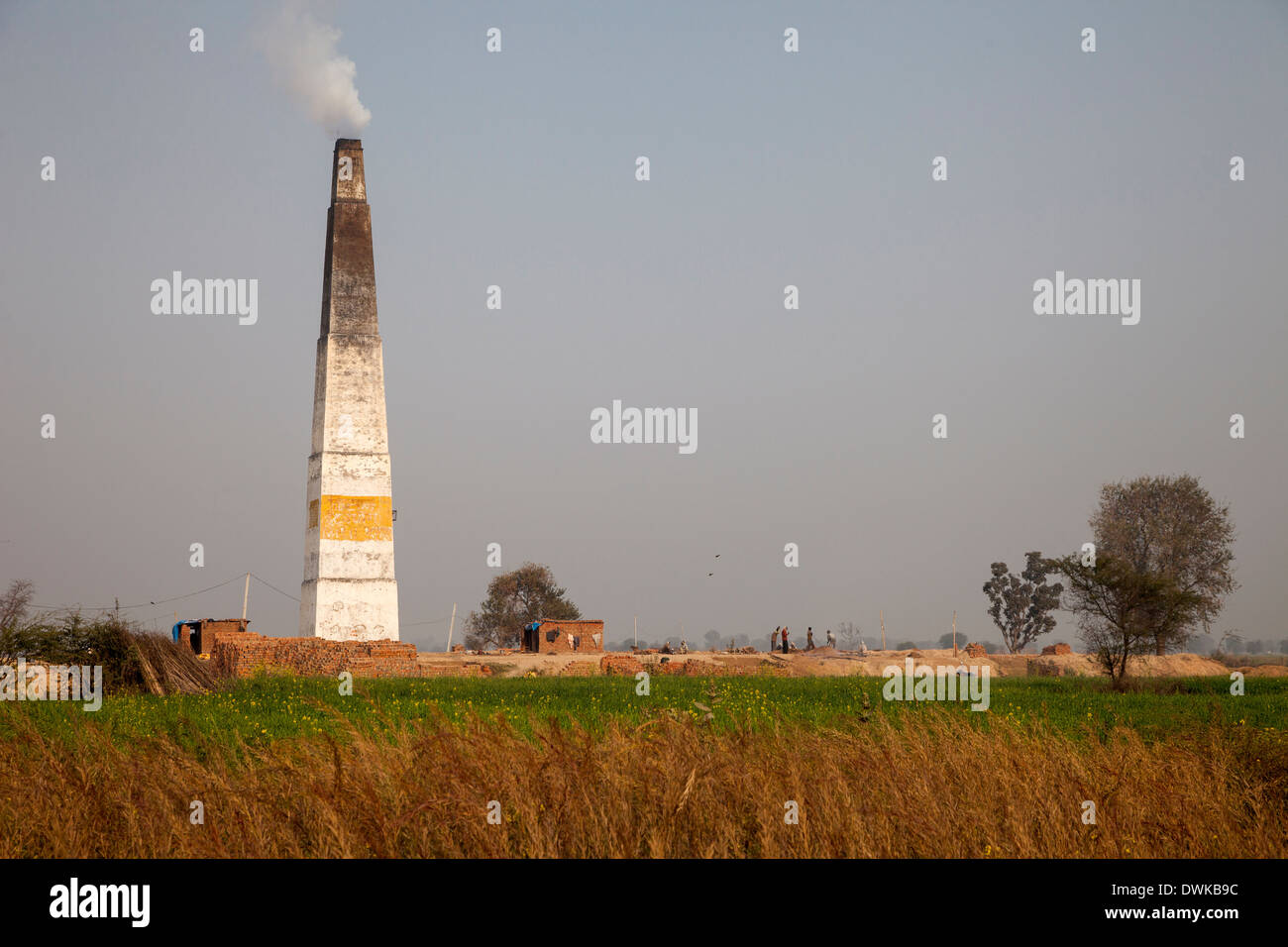 Rajasthan, India. Chimney Emitting Smoke from Underground Ovens Firing Bricks. Stock Photo
