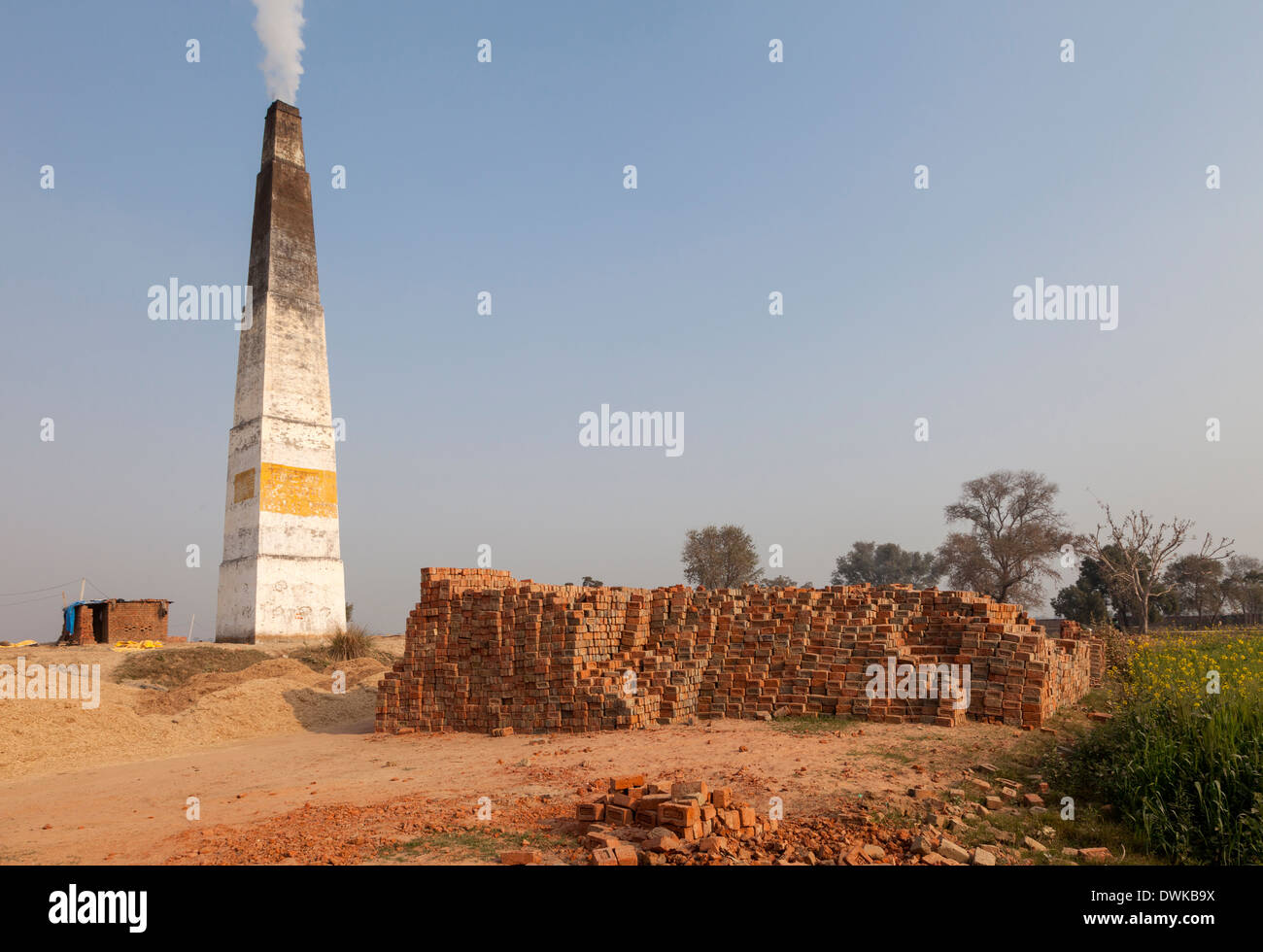 Rajasthan, India. Chimney Emitting Smoke from Underground Ovens Firing Bricks. Stock Photo