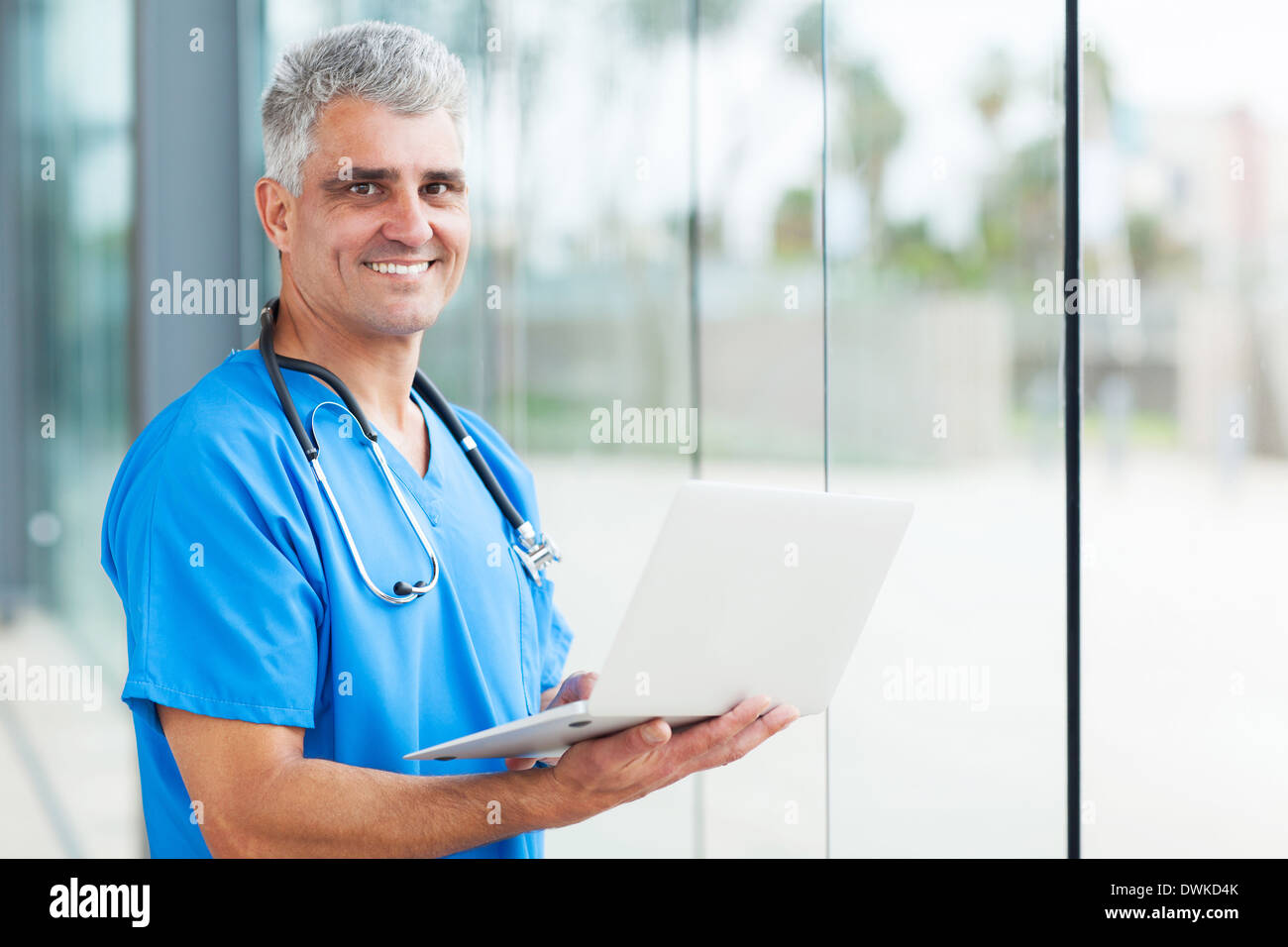 handsome senior male nurse using laptop Stock Photo