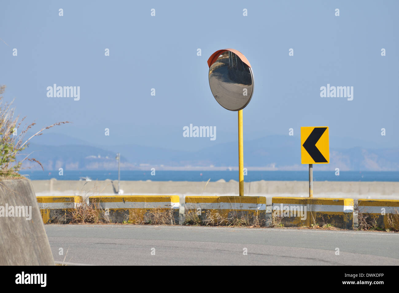 Two Arrow Curve Sign and Convex Mirror on road Stock Photo