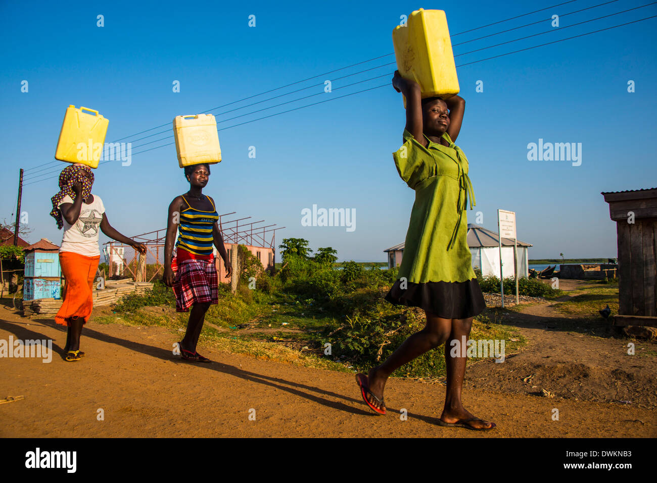 Women carrying water canisters on their head bringing water home from Lake Albert, Uganda, East Africa, Africa Stock Photo
