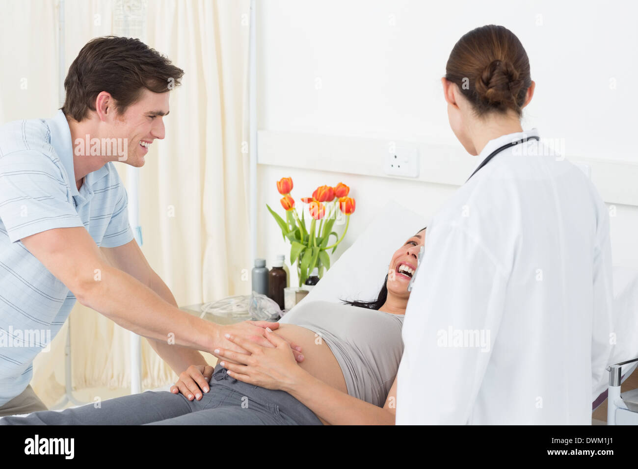 Pregnant couple talking to doctor hi-res stock photography and images ...