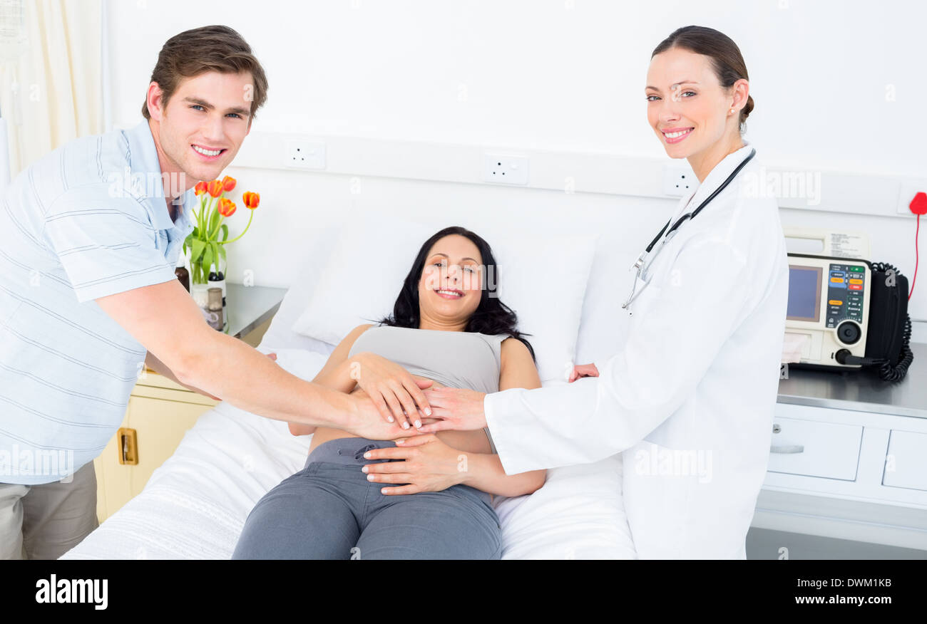 Happy pregnant couple with doctor hi-res stock photography and images ...
