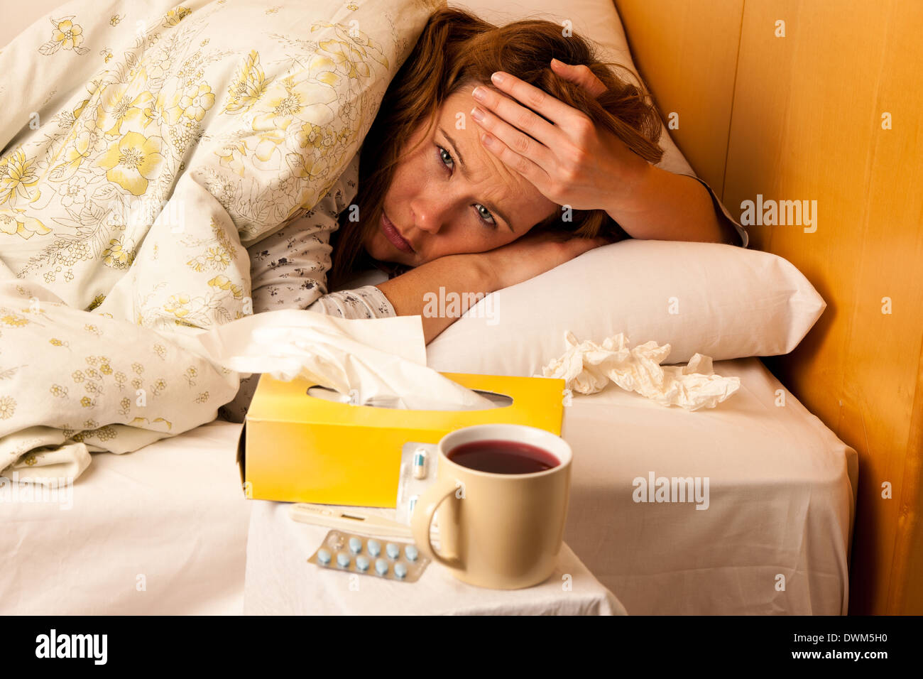Woman with flu resting in bed Stock Photo