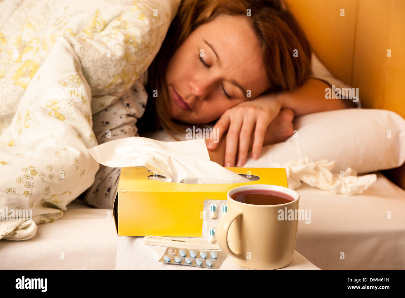 Woman with flu resting in bed Stock Photo