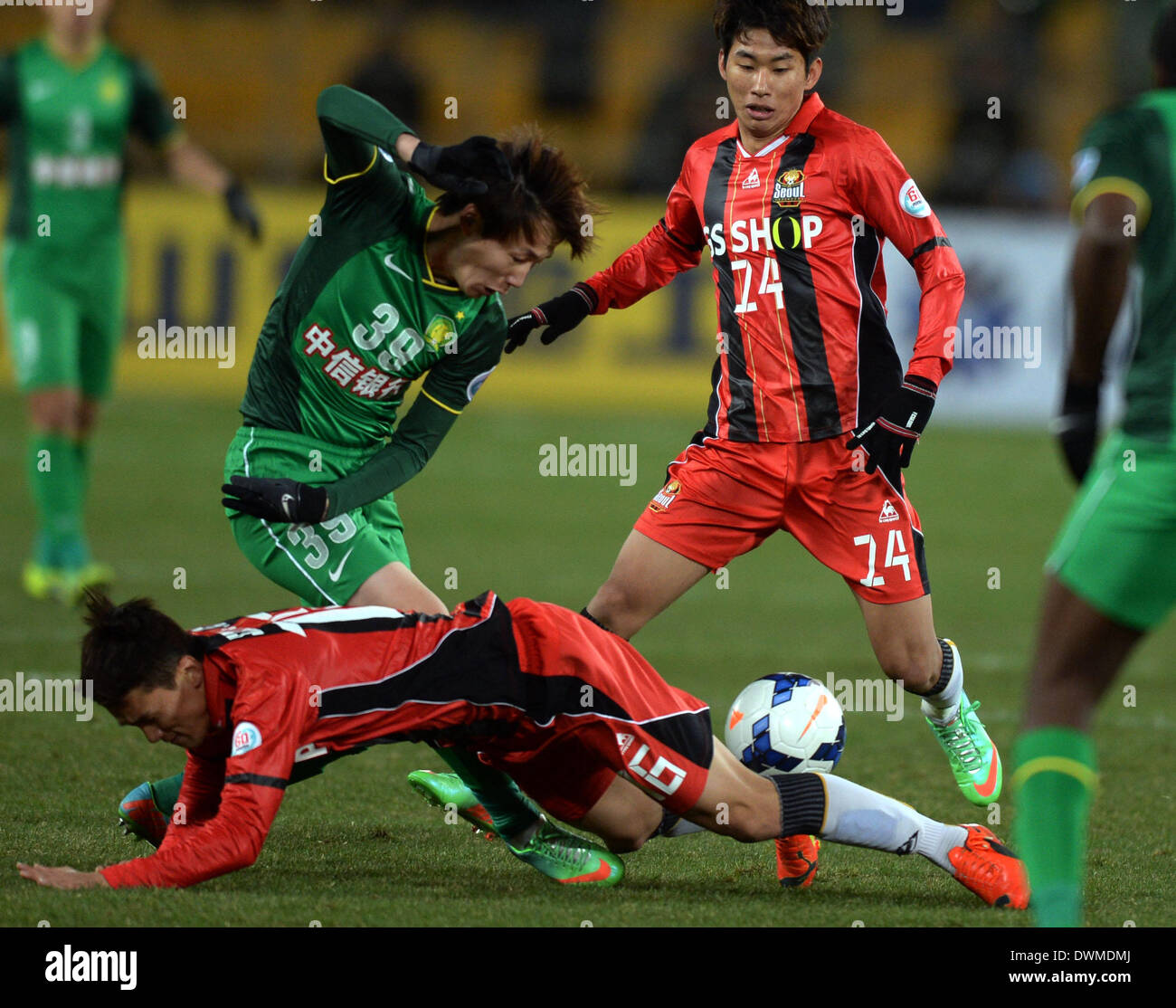 Beijing, China. 11th Mar, 2014. Piao Cheng (Top, L) of Beijing Guoan vies with Kang Seung Jo (Bottom) of FC Seoul during their AFC Champions League 2014 Group F football match in Beijing, capital of China, on March 11, 2014. The match ended with a 1-1 tie. Credit:  Kong Hui/Xinhua/Alamy Live News Stock Photo
