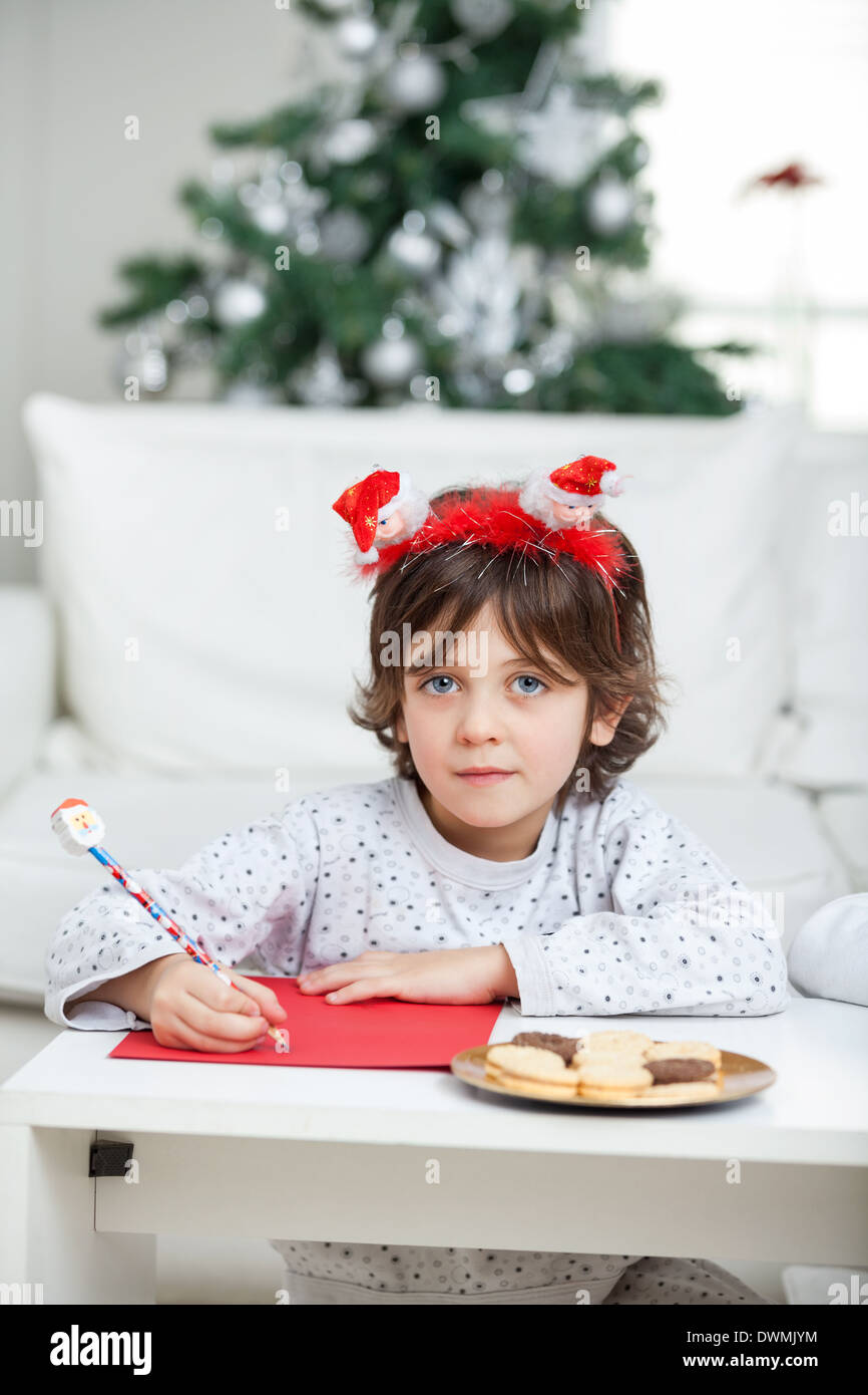 Boy wearing headband writing letter hires stock photography and images