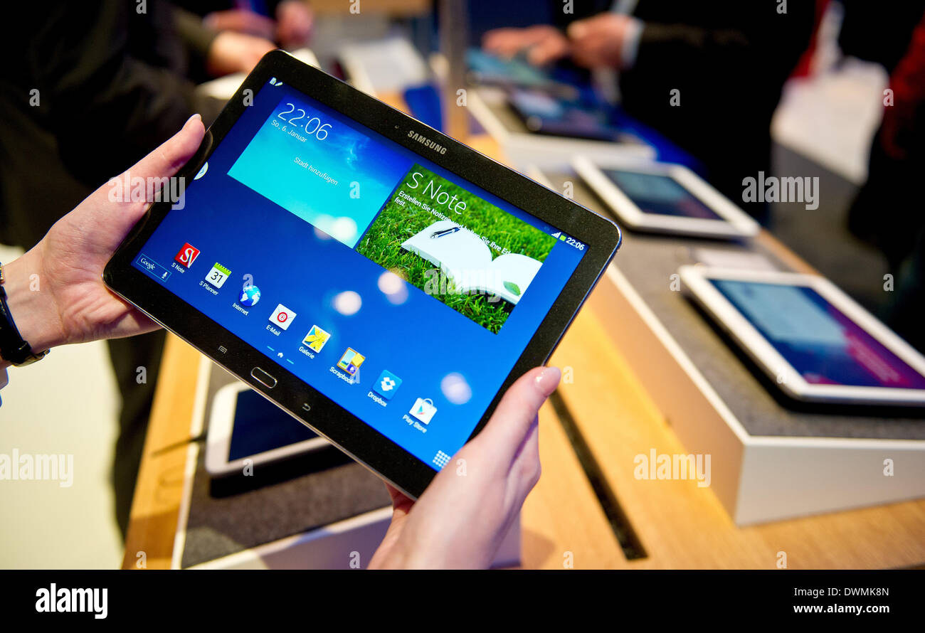 Hanover, Germany. 11th Mar, 2014. A woman holds up the new 'Samsung GALAXY  Note 10.1 LTE 2014' tablet computer at the Vodafonde exhibition stand at  the CeBIT fair in Hanover, Germany, 11
