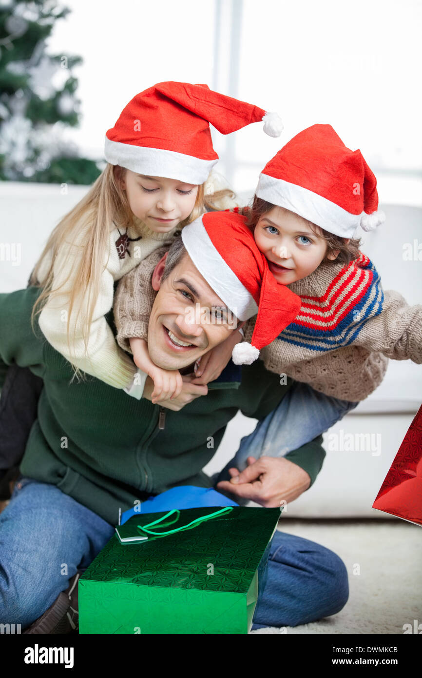 Father Piggybacking Children During Christmas Stock Photo