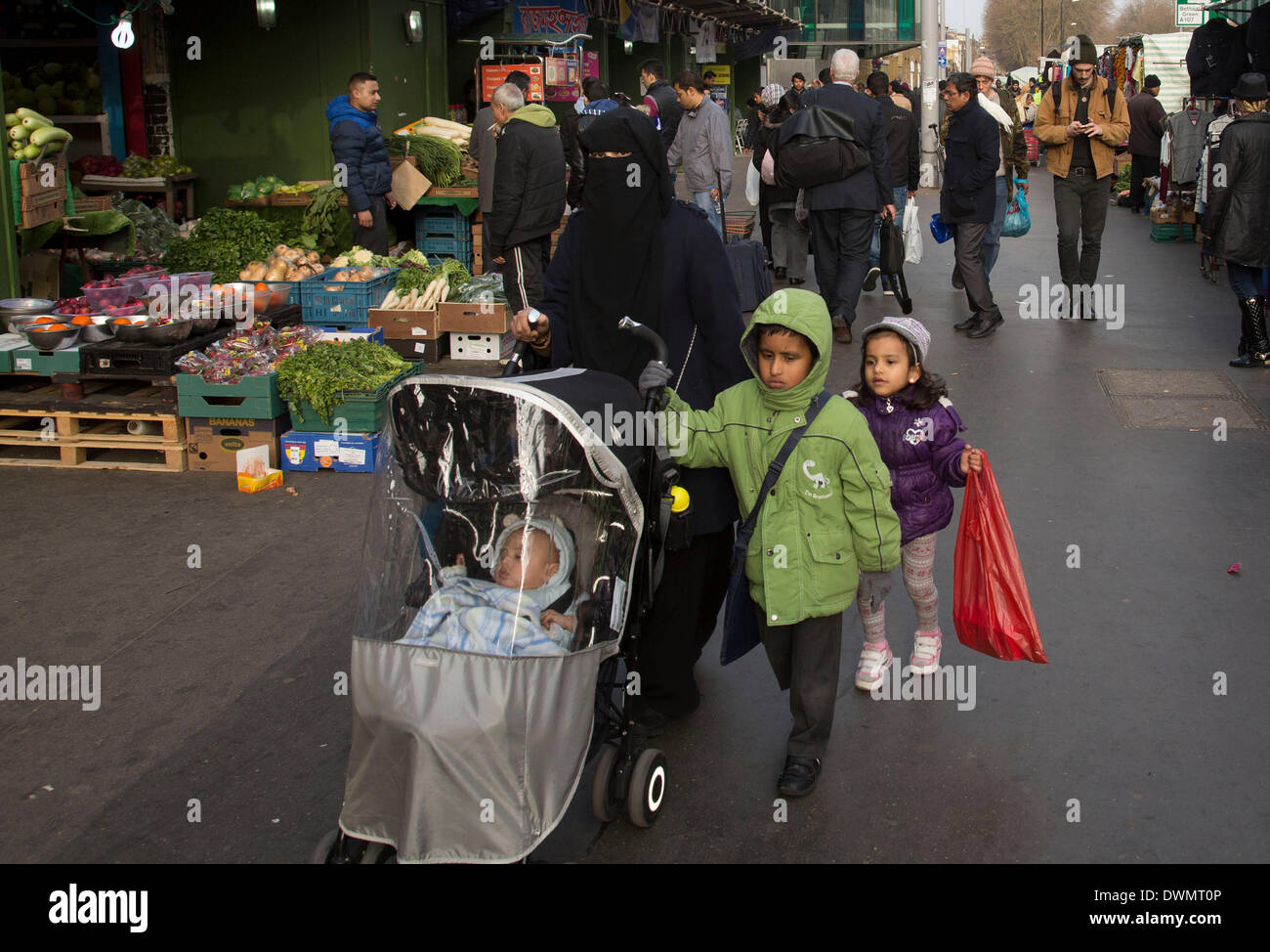 Whitechapel, London, UK. 11th Mar, 2014. People from various ethnic backgrounds around the market on Whitechapel High Street in East London. This area in the Tower Hamlets is predominantly Muslim with just over 50% of Bangladeshi descent. This is known as a very Asian and multi cultural part of London's East End. Credit:  Michael Kemp/Alamy Live News Stock Photo