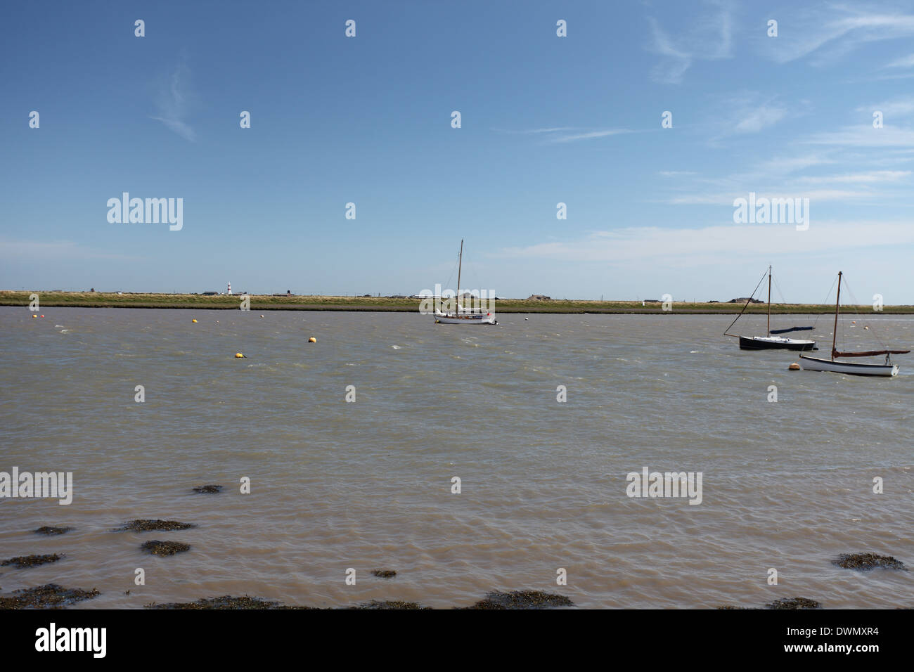 Boats on the river Ore with Orfordness in the background, Suffolk Stock Photo