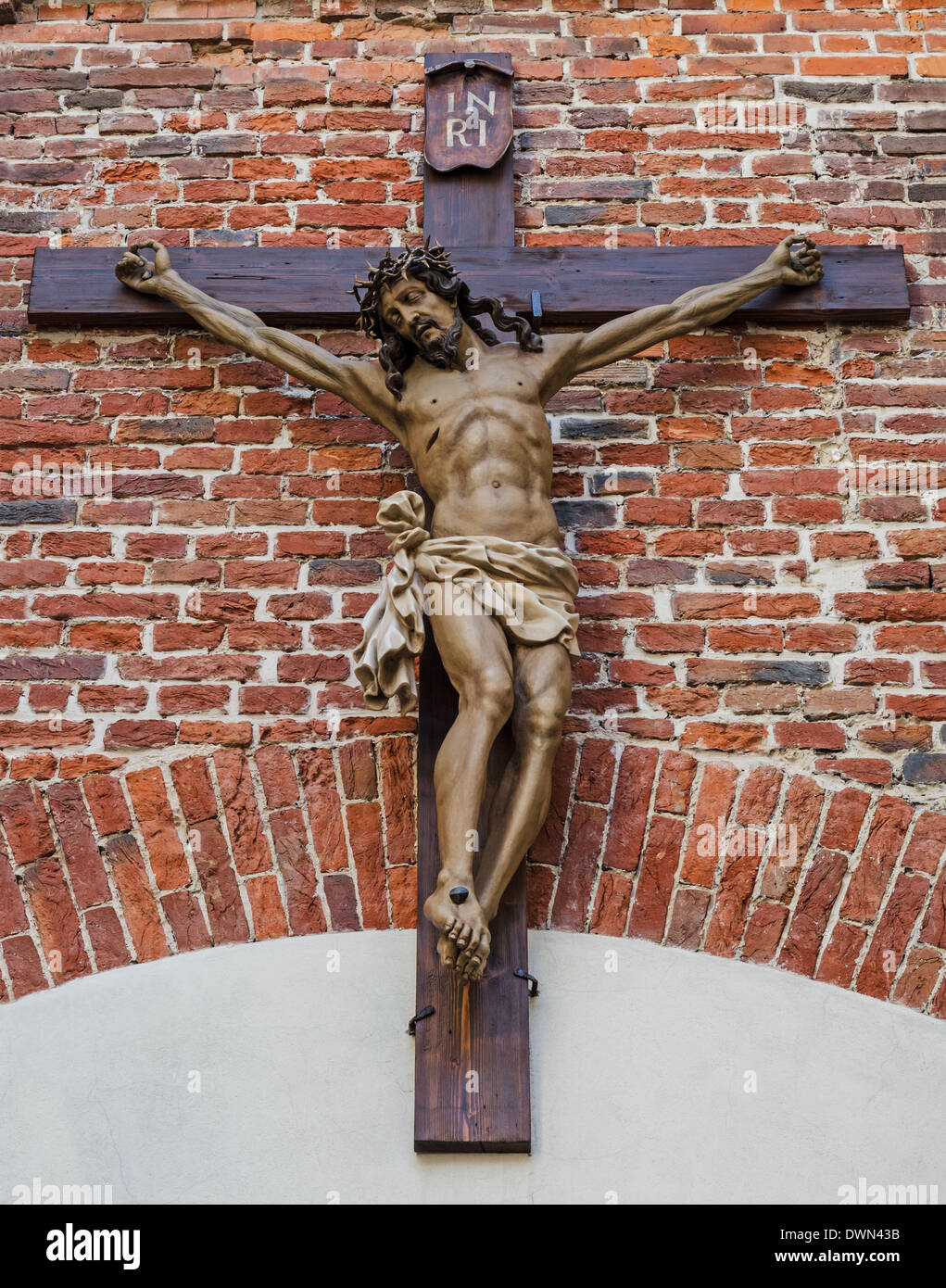 Crucifixion of Jesus Christ on red brick wall Stock Photo