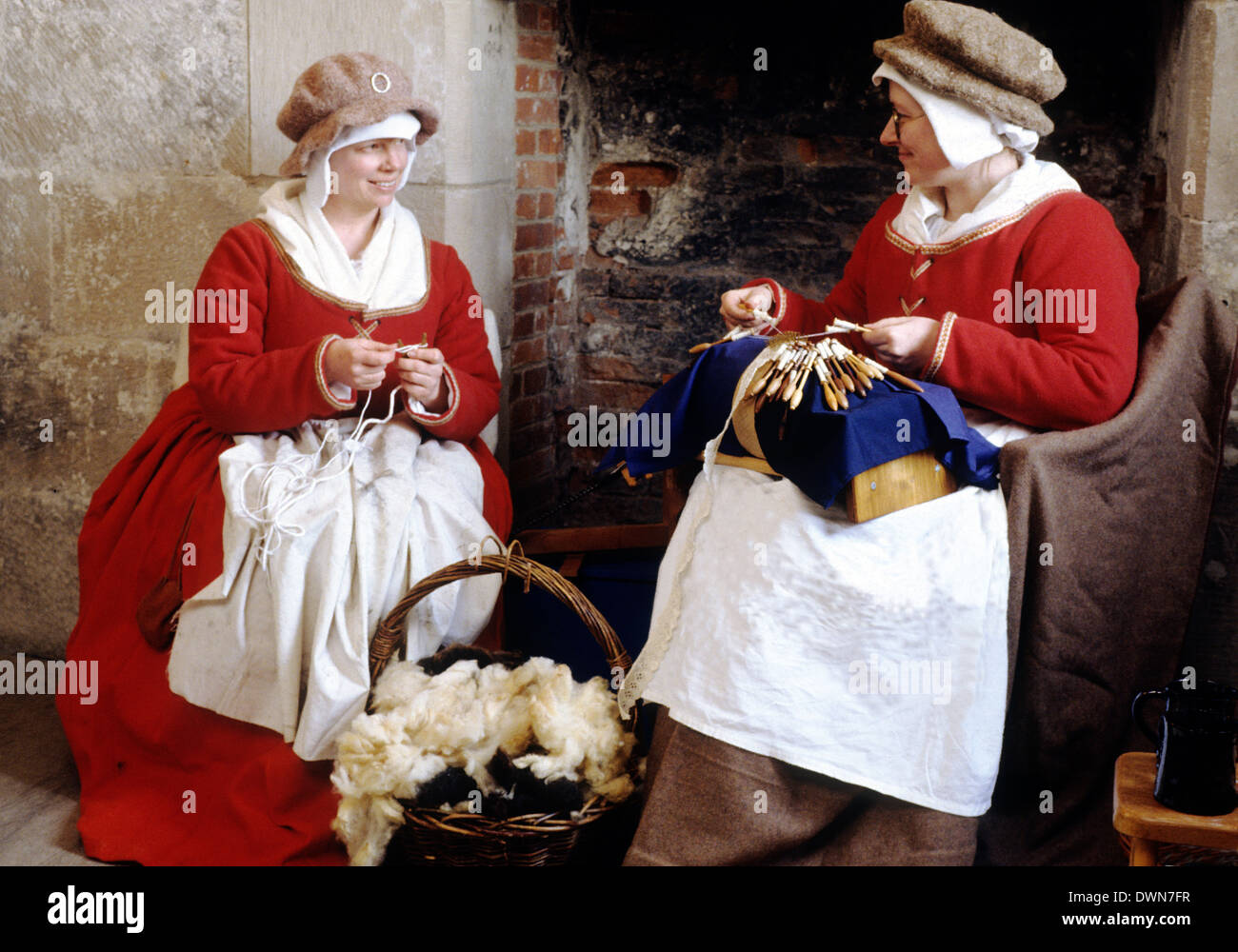Tudor Period women, domestic labours, spinning wool, making lace, late 16th century English historical re-enactment women fashion fashions costume costumes England UK Stock Photo
