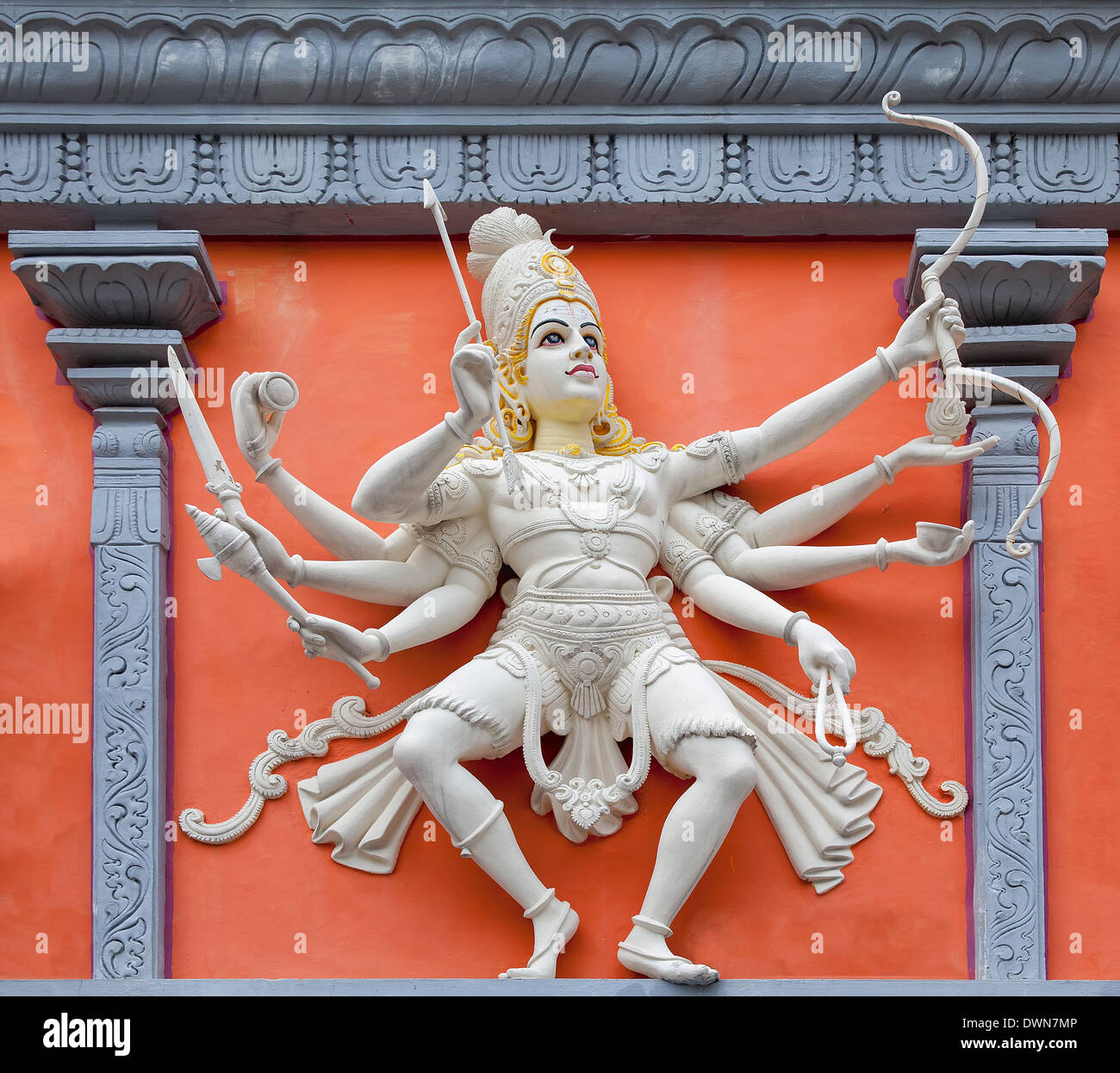Nataraj Dancing Form of Lord Shiva with Bow and Arrow Hindu God Orange and White Statue on Temple Exterior Wall Relief Stock Photo