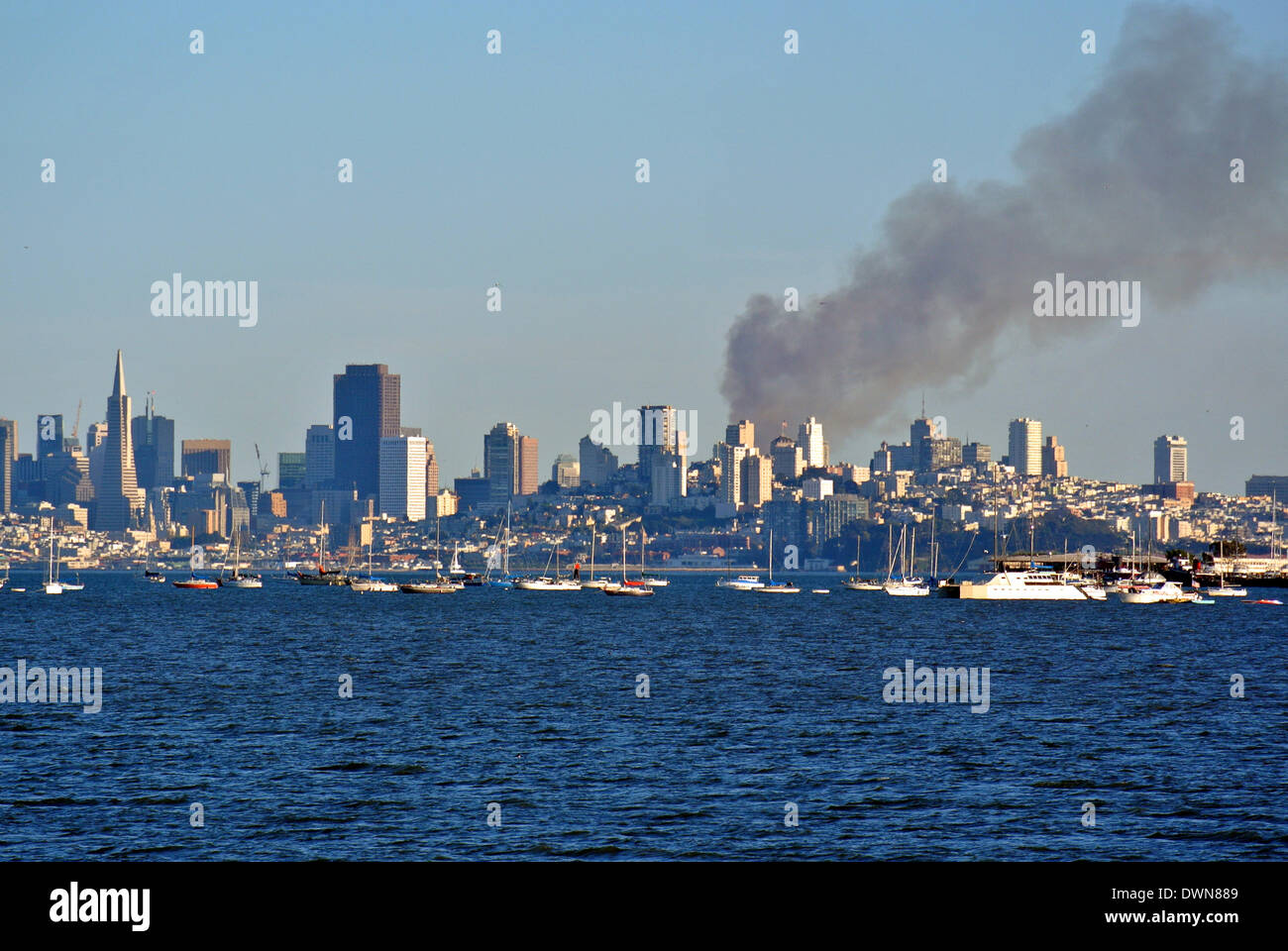 San Francisco, USA. 11th March 2014. plumes of smoke rise high in the skyline over Mission Bay in  San Francisco from a 5 alarm fire in a multi unit apartment building under construction. Firefighters say the fire is under control and the cause of the fire is unknown. Credit:  Bob Kreisel/Alamy Live News Stock Photo