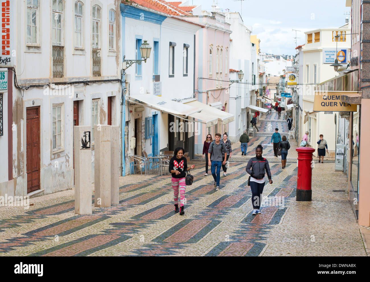 People walking along Lagos street after rain Algarve, Portugal, Europe Stock Photo