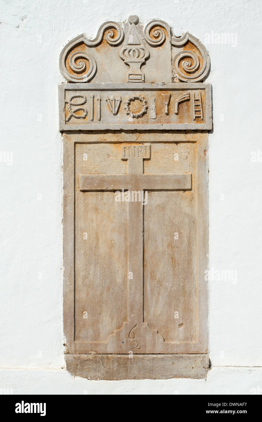 Stone carving of a cross and religious symbols on a church within Tavira Algarve  Portugal Europe Stock Photo