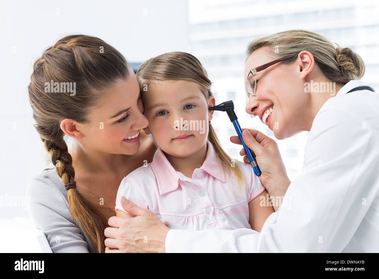 Girl being examined by doctor with otoscope Stock Photo