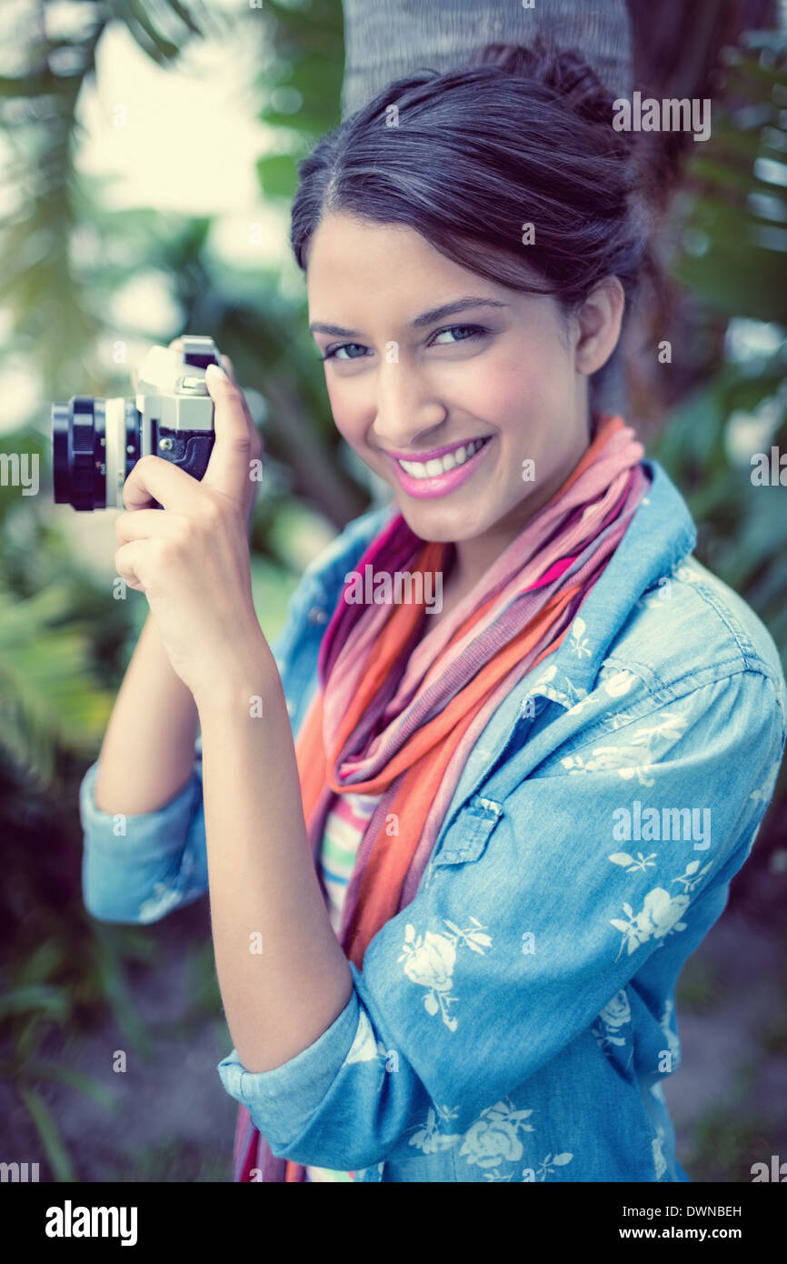 Cheerful brunette taking a photo outside smiling at camera Stock Photo