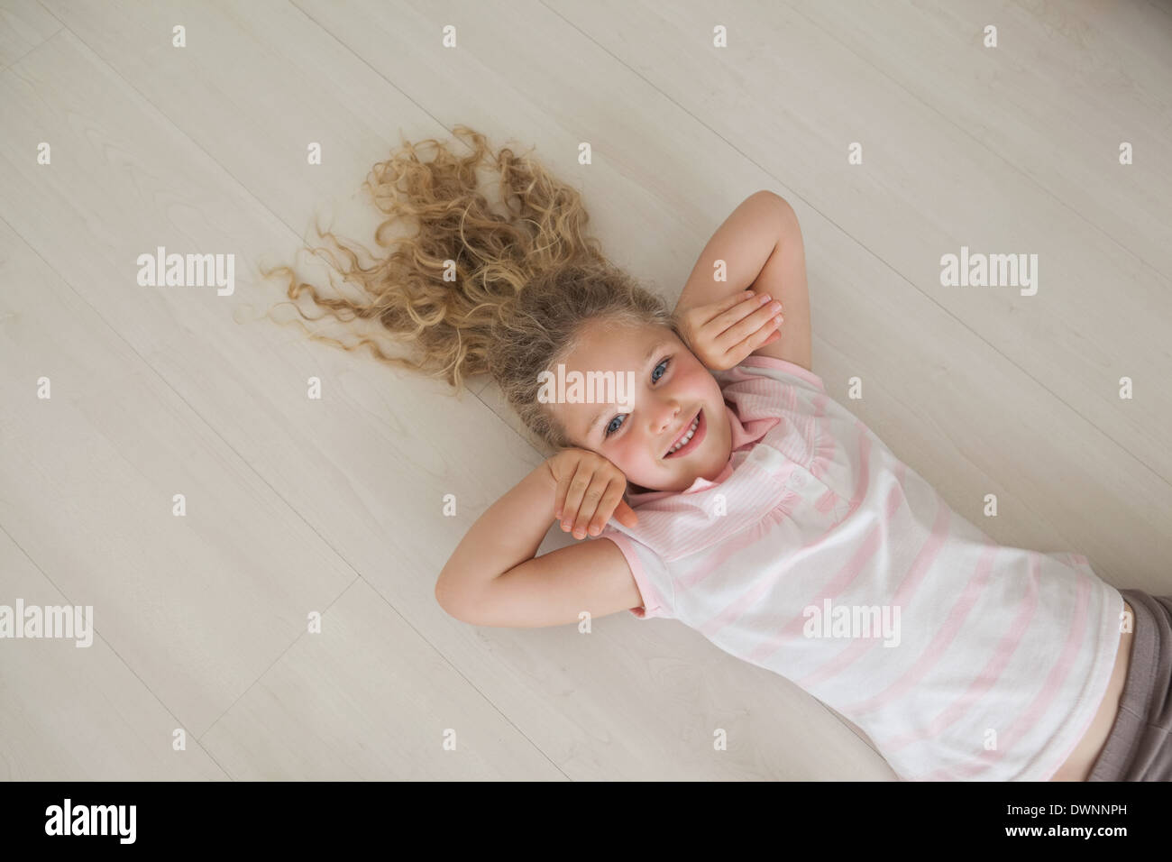 High angle portrait of a smiling girl lying on floor Stock Photo - Alamy