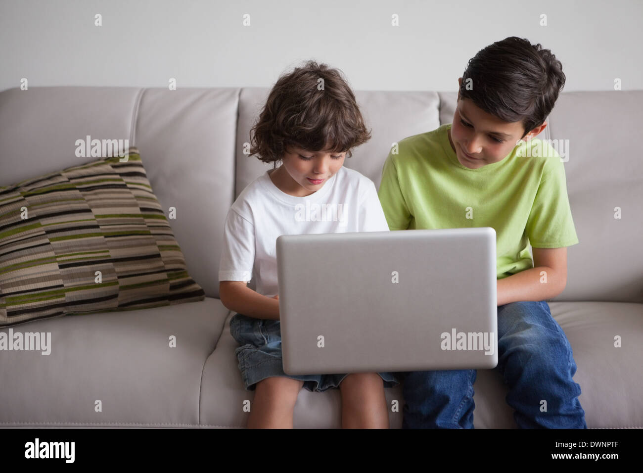 Young boys using laptop in the living room Stock Photo - Alamy
