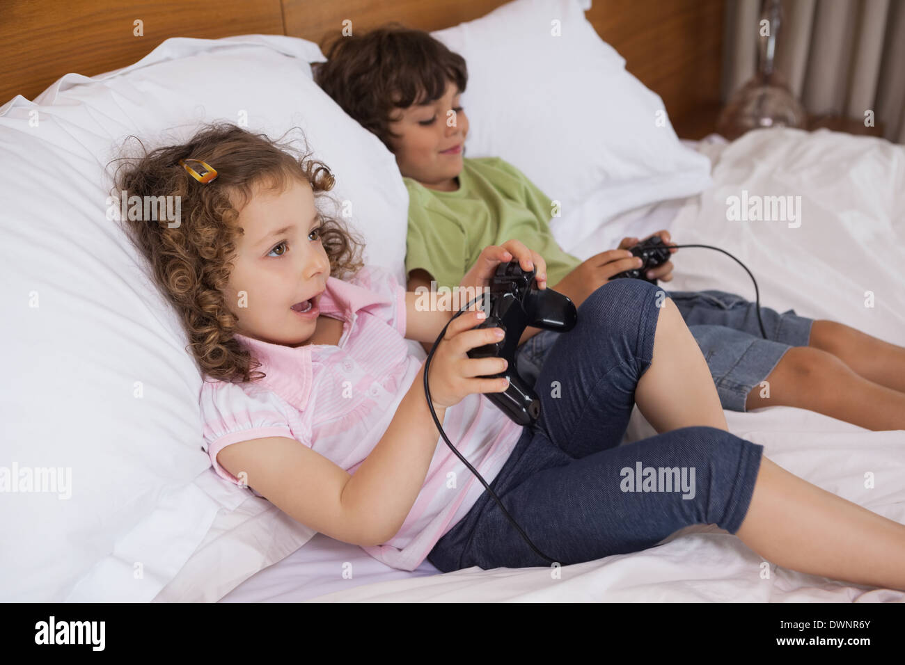 Brother and sister playing video games in bedroom Stock Photo Alamy