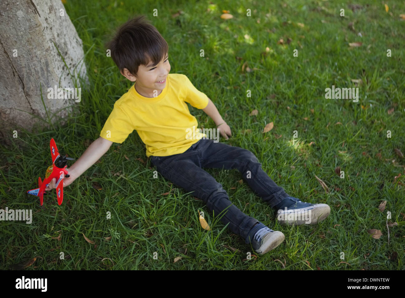Young boy playing with a toy plane at park Stock Photo - Alamy